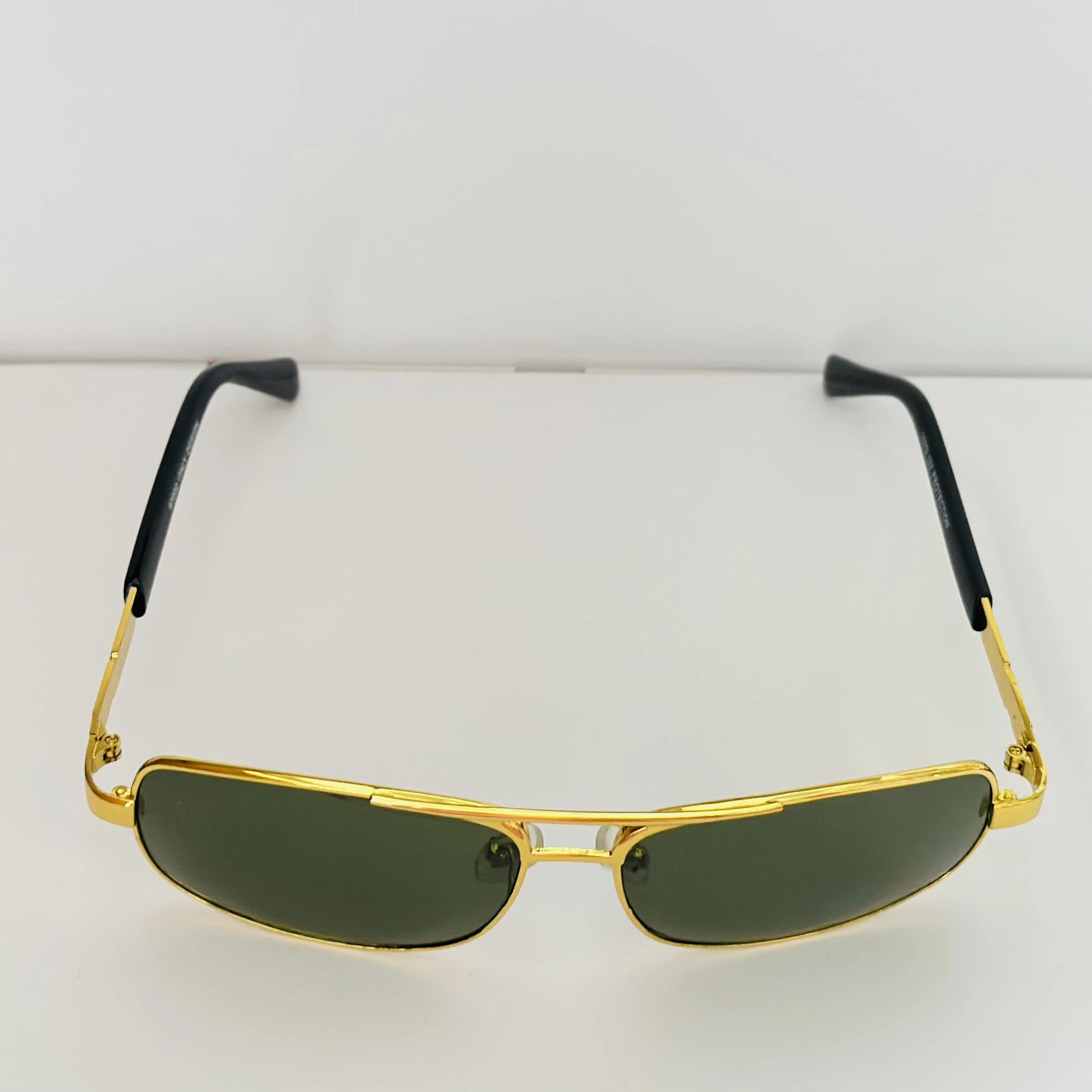 Gold aviator-style sunglasses with green lenses.