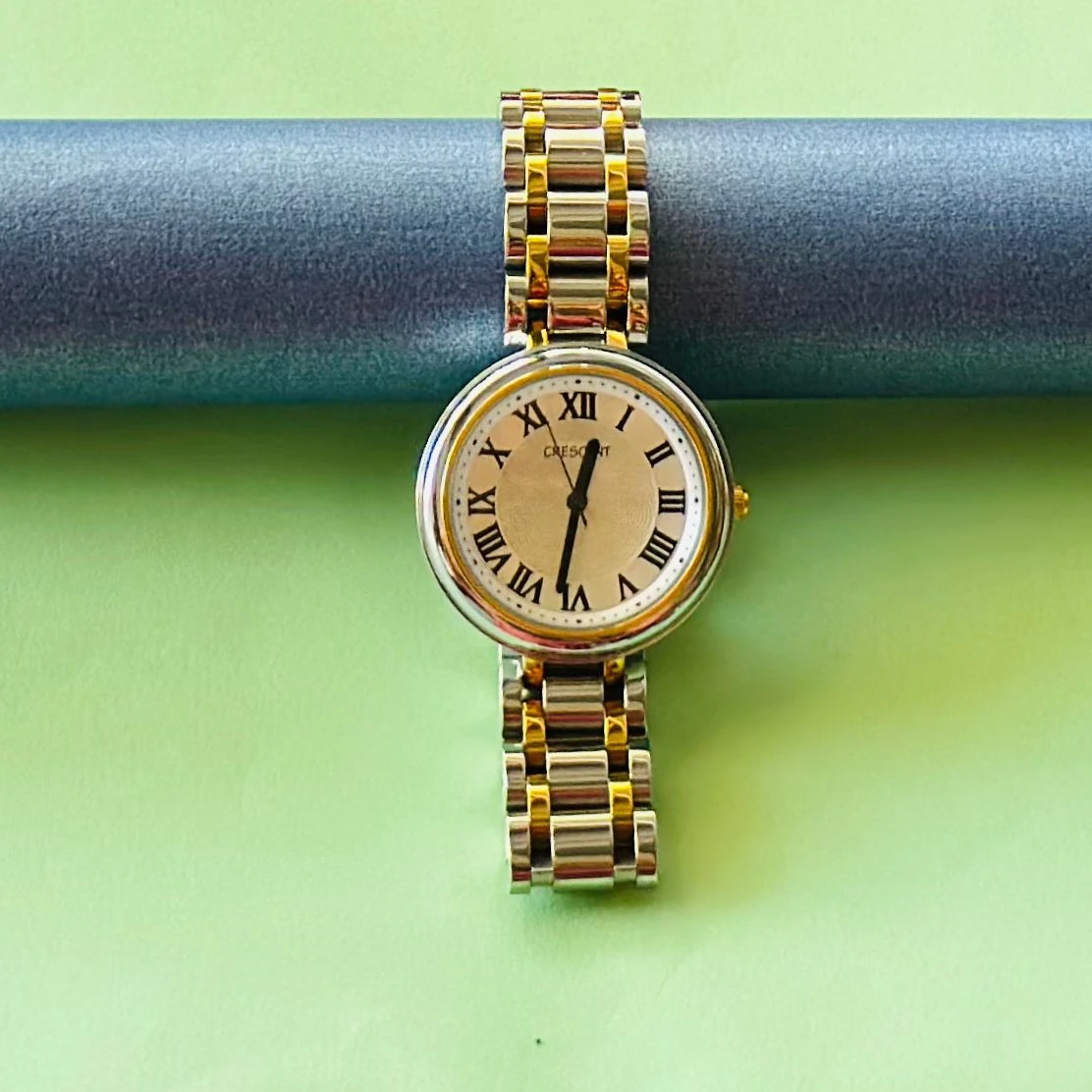 Crescent analog watch with a rectangular case and a two-tone (silver and gold) metal bracelet.