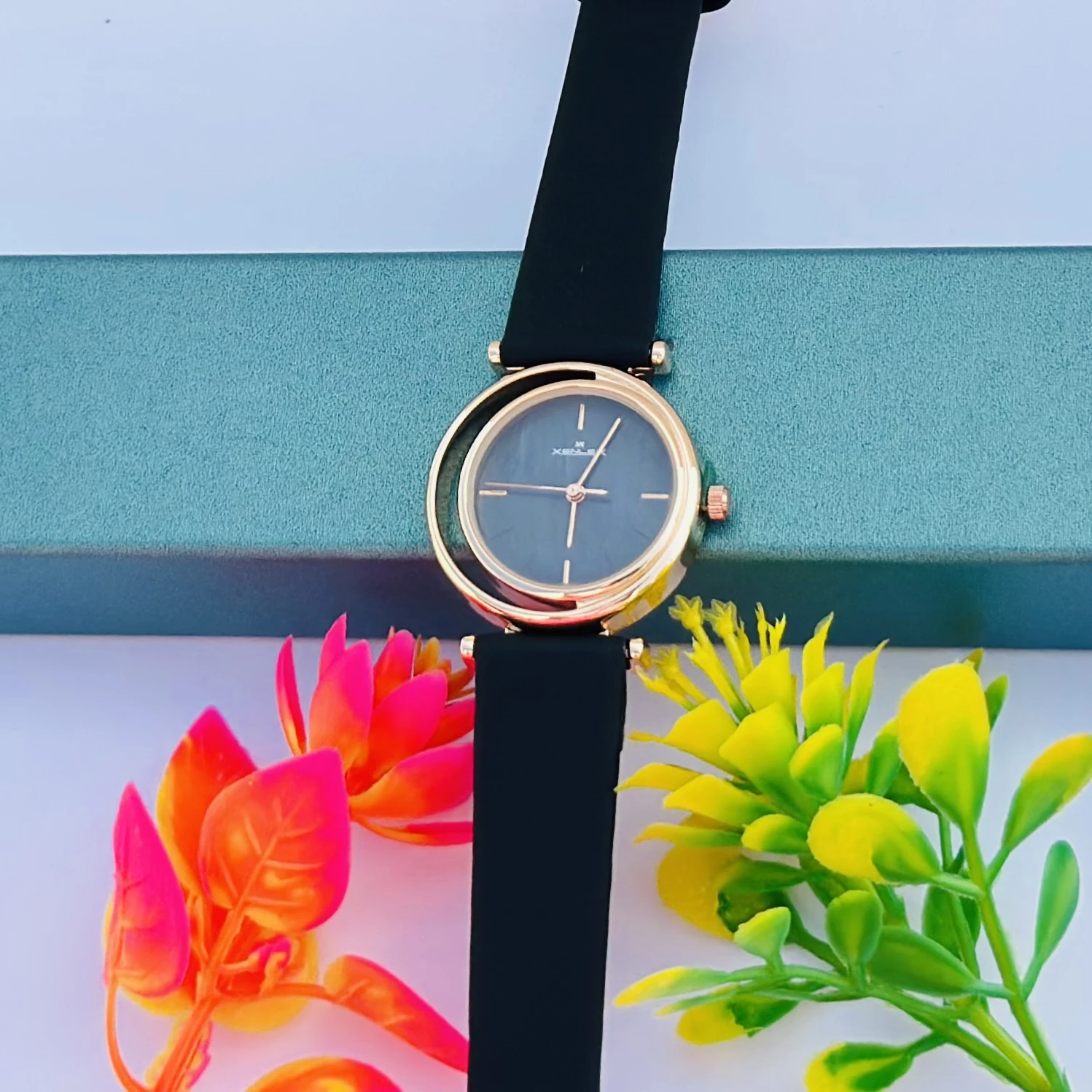 Analog with Pink Dial watch for women with a black plastic strap.