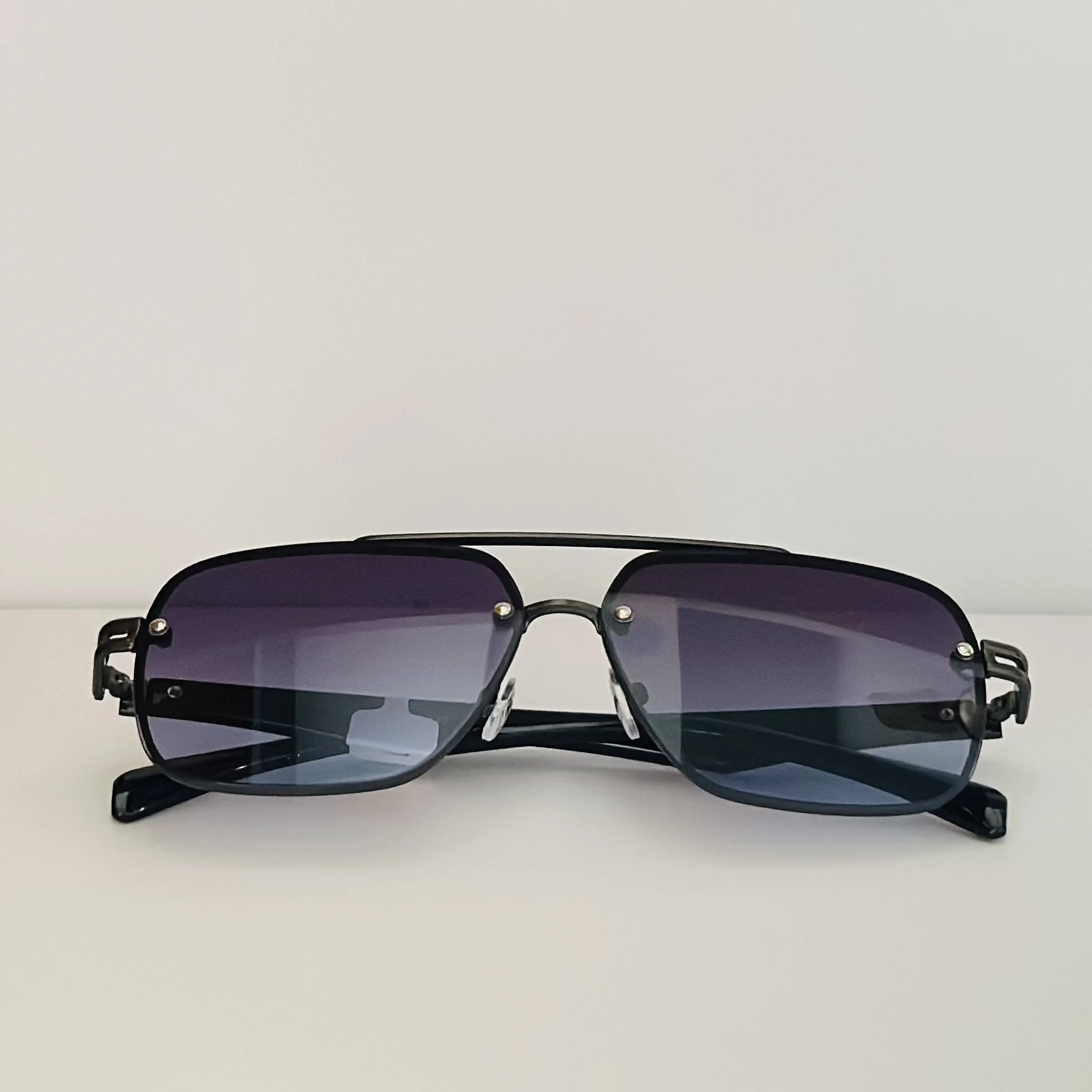 black rimless aviator sunglasses with blue gradient lenses.