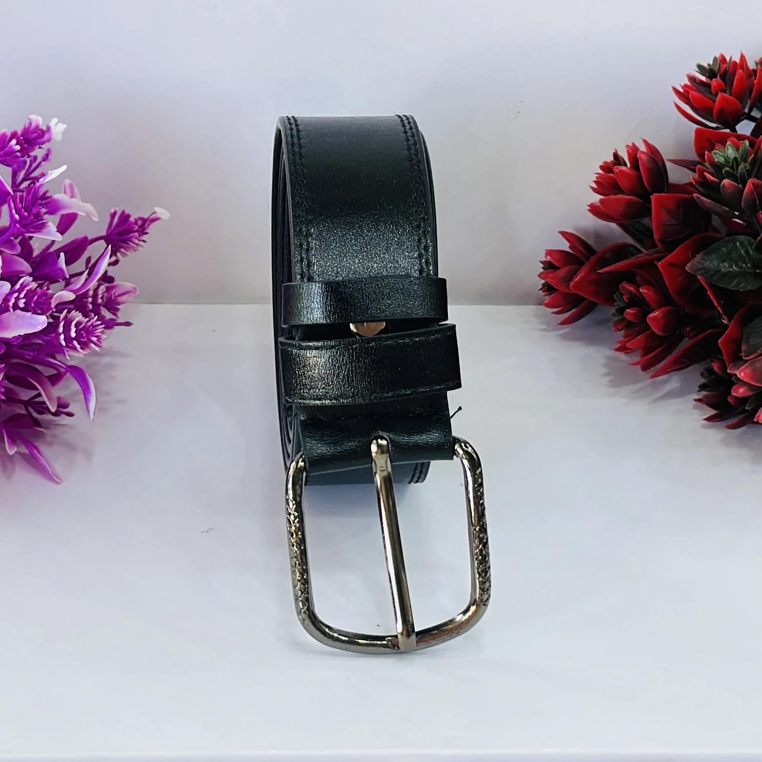 Men’s black leather belt with a metal buckle.