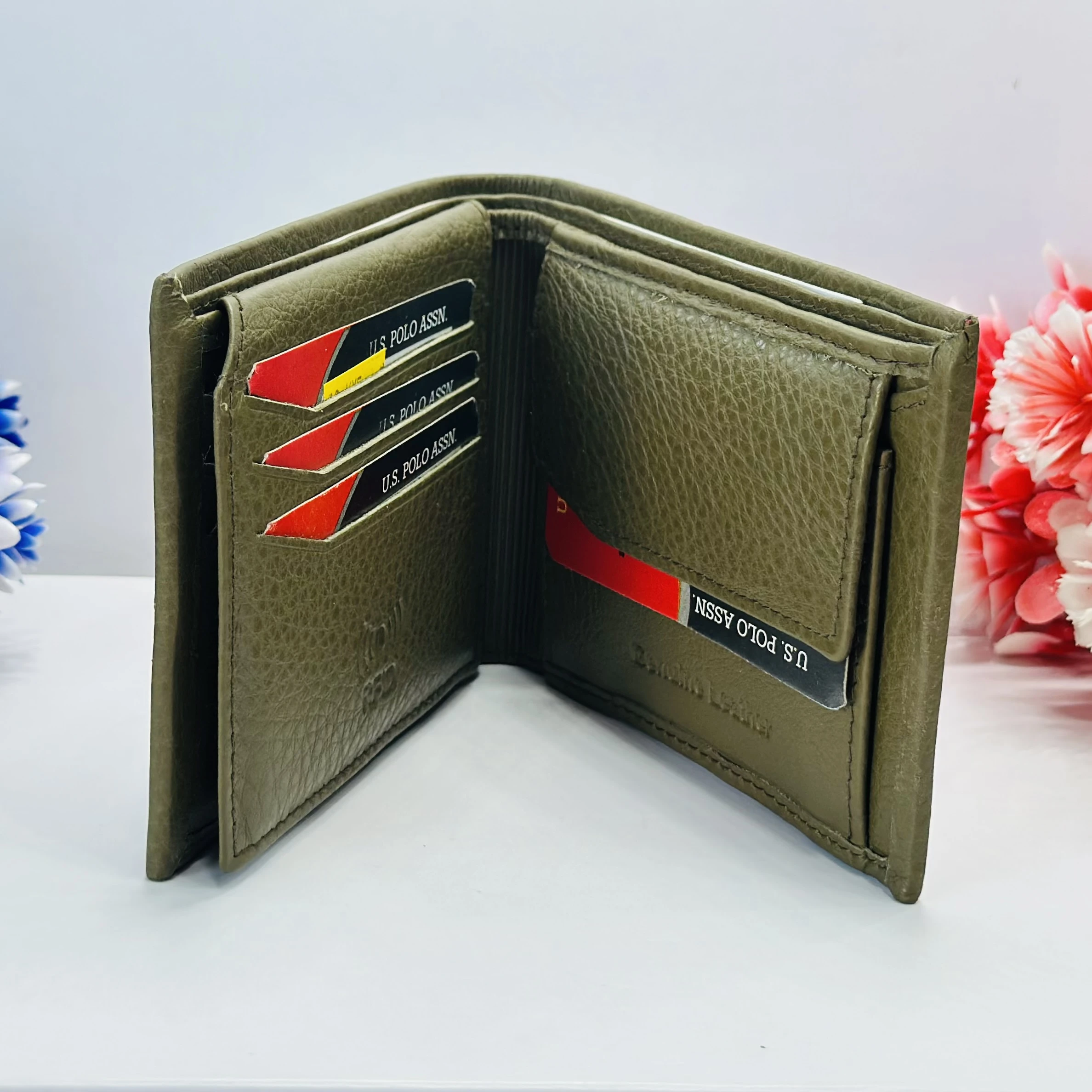 U.S. Polo Assn. men's bi-fold wallet in olive green grained leather.