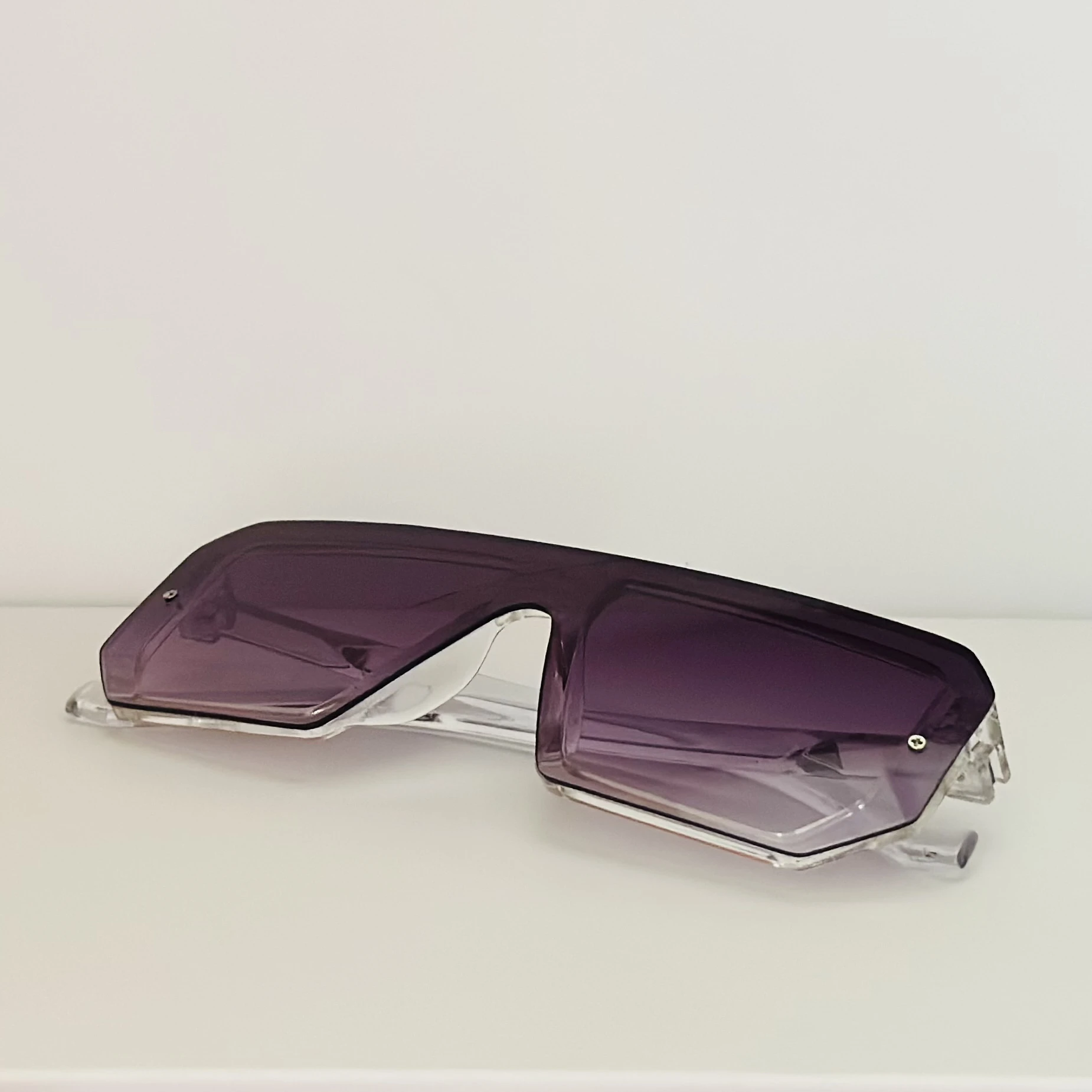 Oversized shield sunglasses with a rimless, flat-top design and purple gradient lenses.