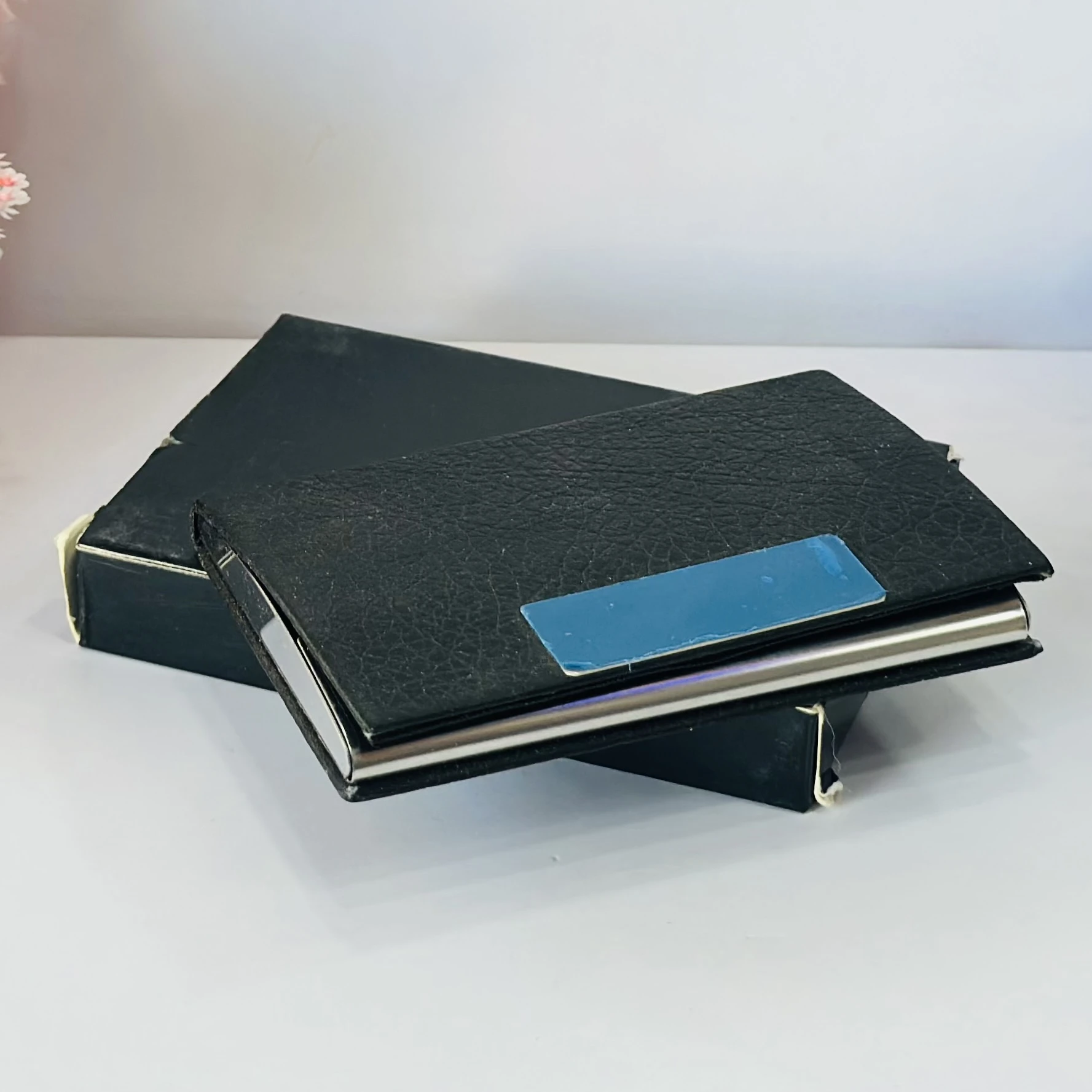 Black faux leather and metal business card holder.