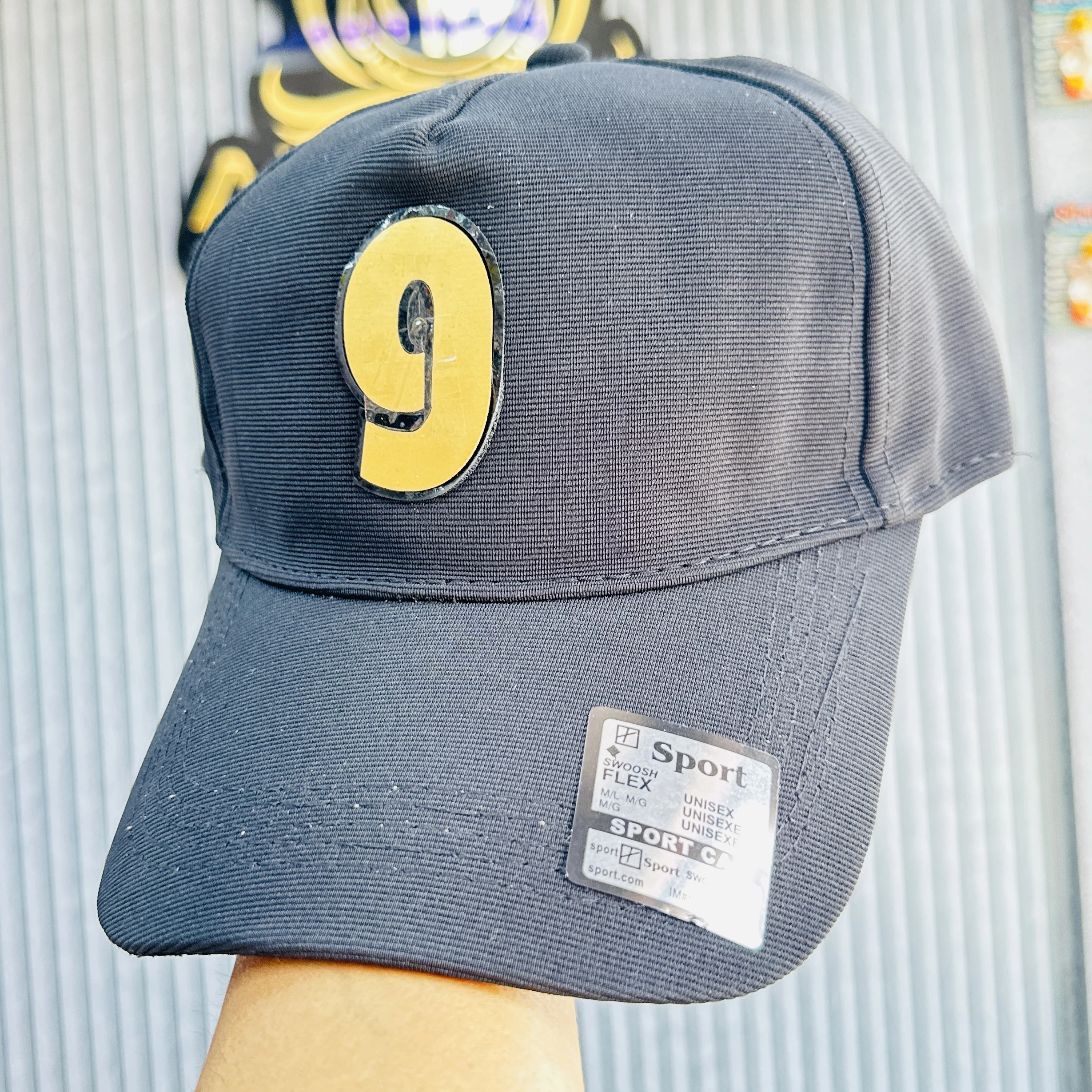 cap features a prominent yellow and black number '9' patch on the front.