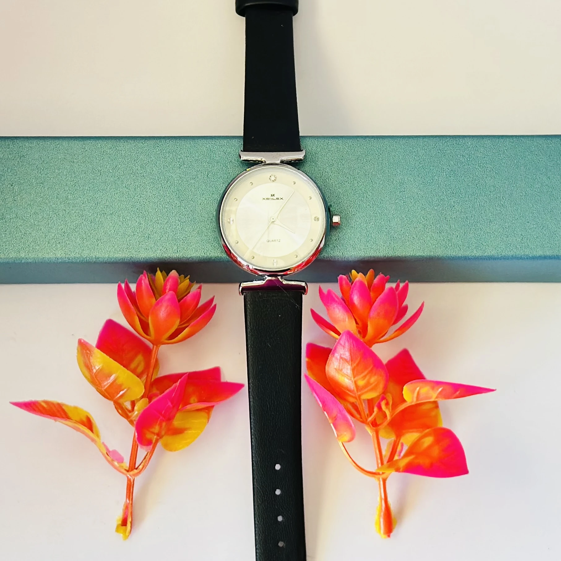 Analogue watch for women with a black leather strap.