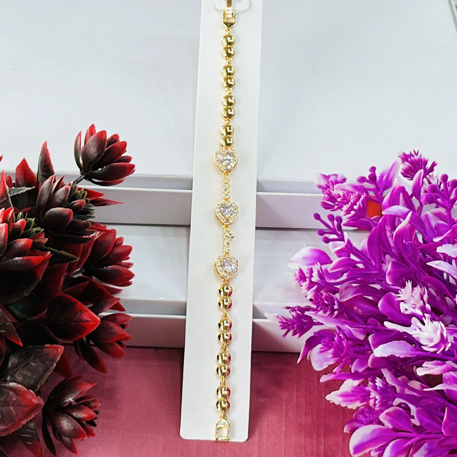 Gold plated women's bracelet with a heart design and cubic zirconia stones.