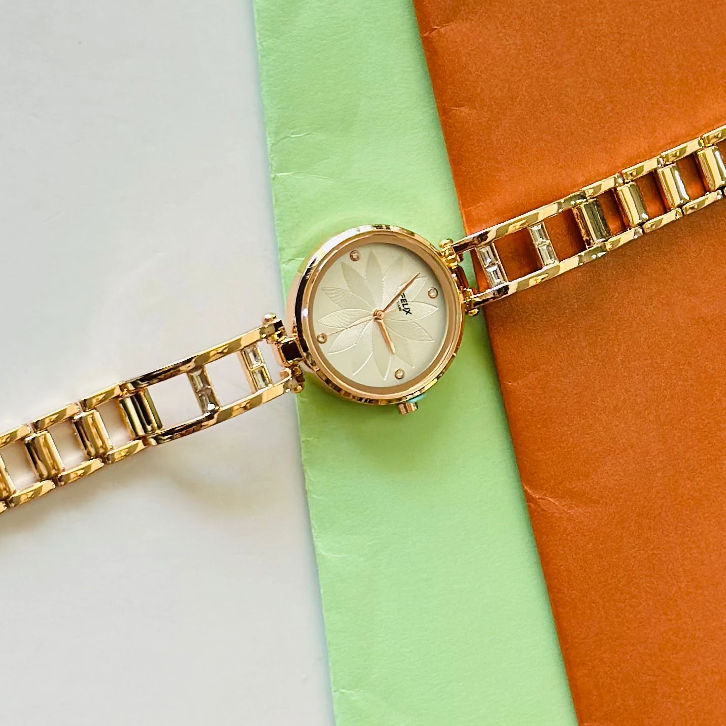 analog watch with a white dial and a rose gold metal strap