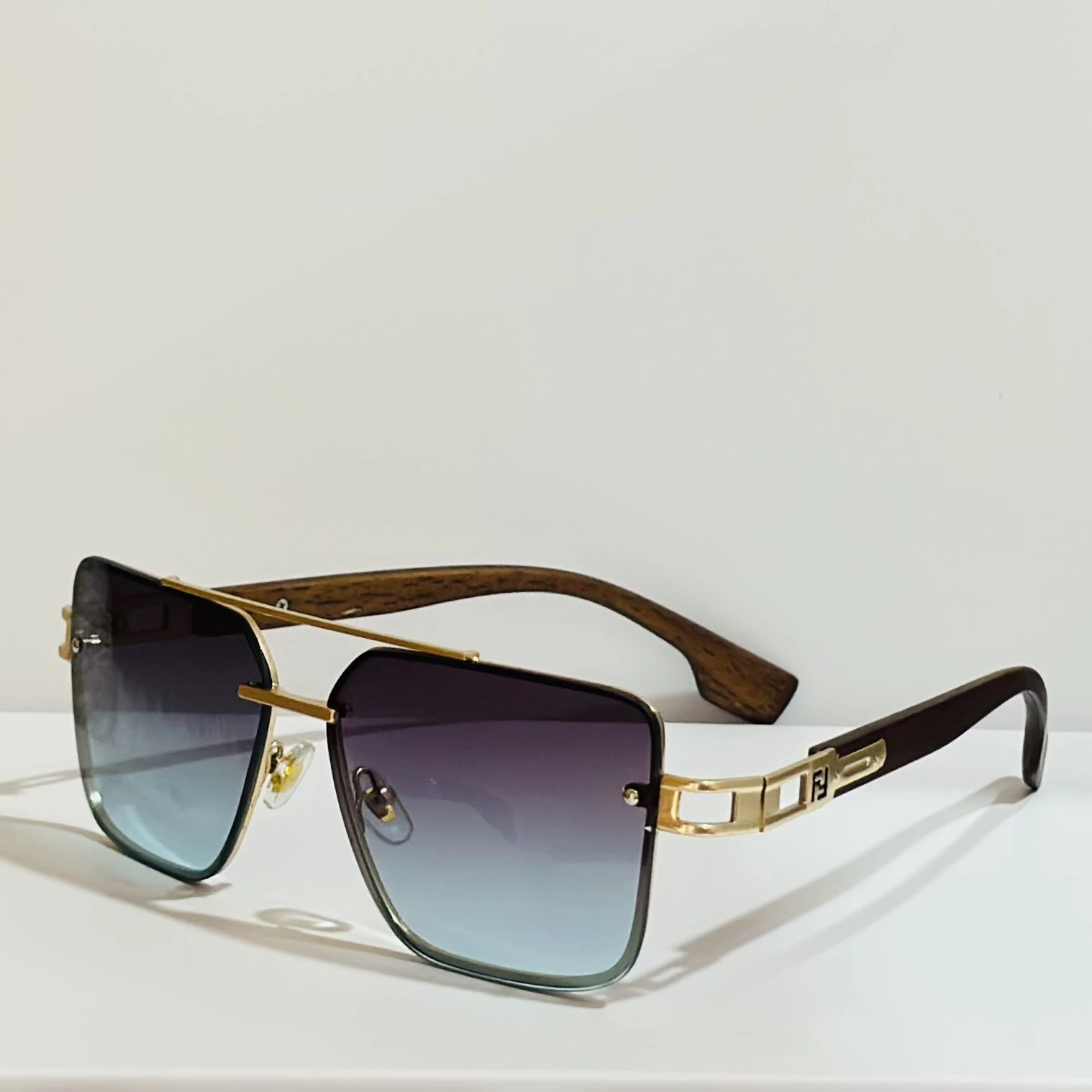Pair of of aviator-style sunglasses with a gold-tone metal frame and blue gradient lenses.