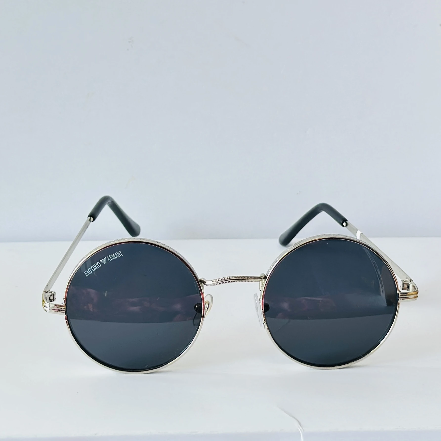 Emporio Armani sunglasses feature a distinctive round metal frame design.