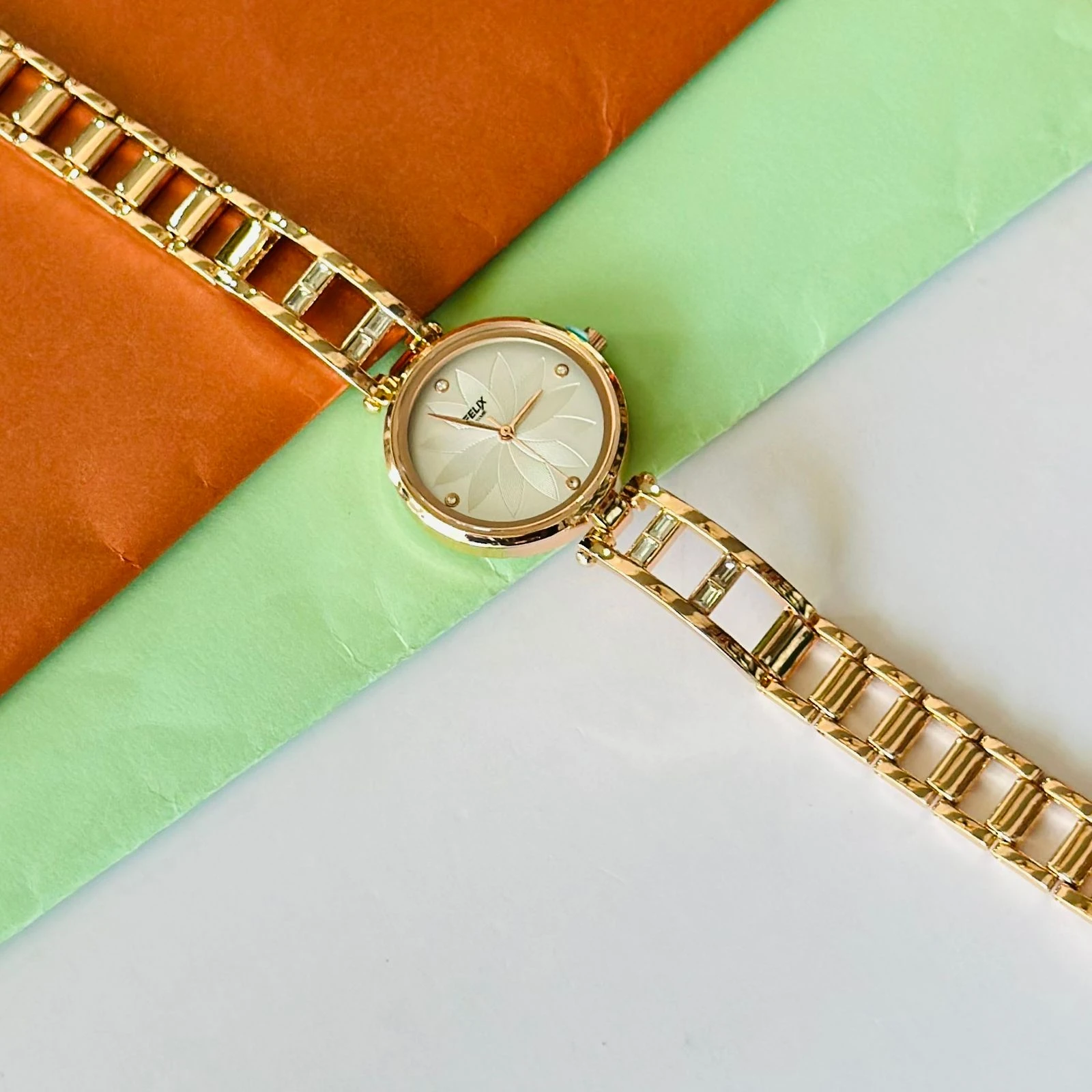 analog watch with a white dial and a rose gold metal strap