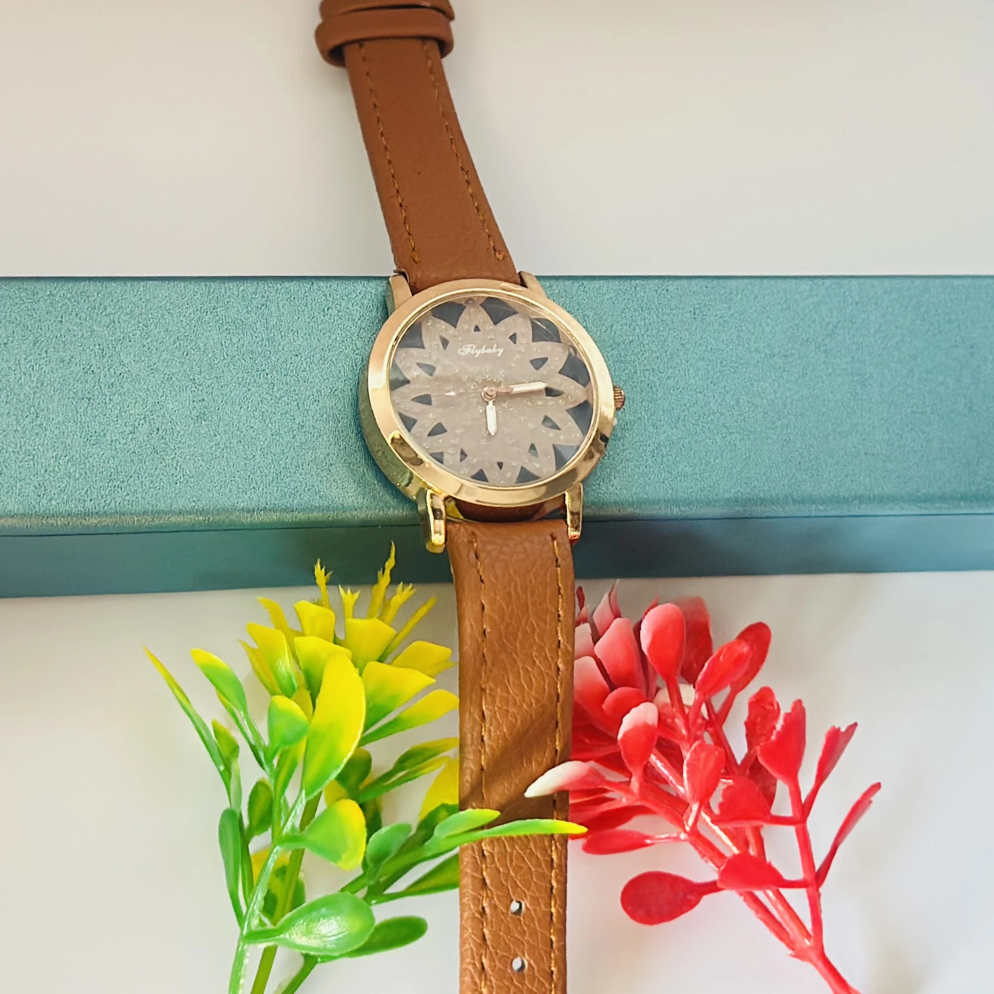 Flybaby flower watch with a peach/tan faux leather strap.