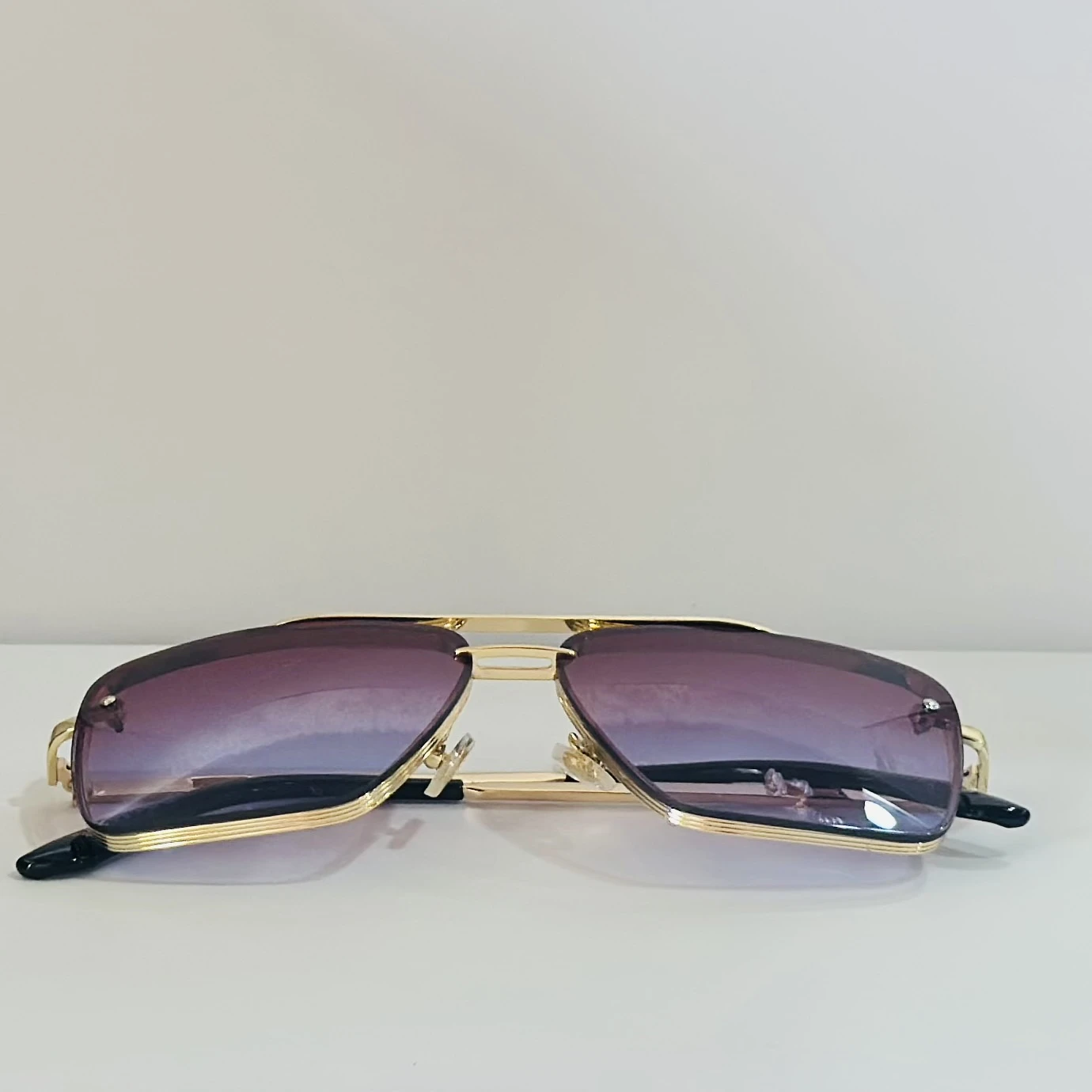 Sunglasses in a gold-tone metal frame with gradient lenses.