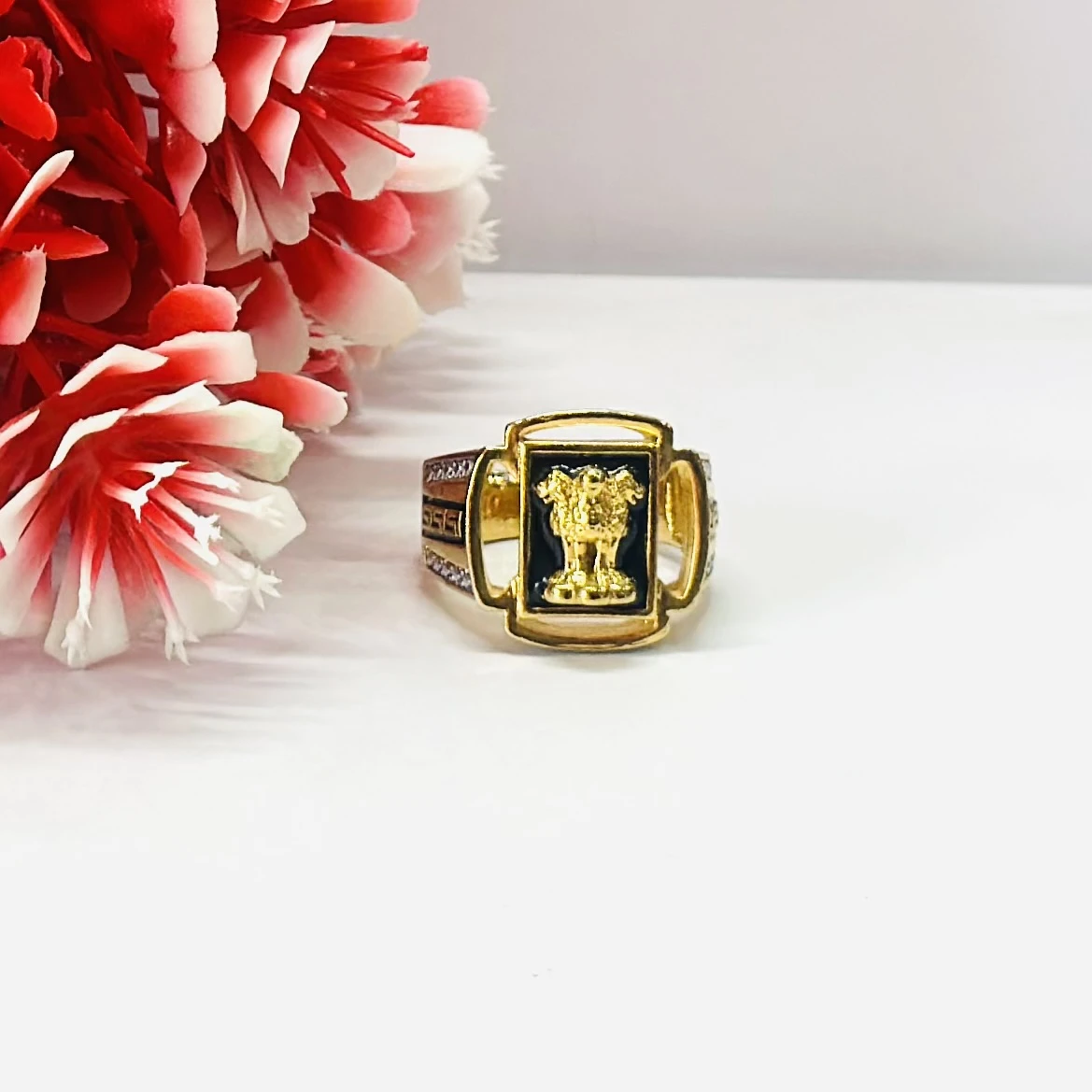 Gold -toned men's signet ring with black accent stones and engraved text.