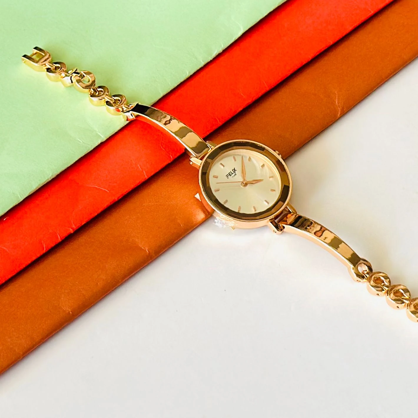 analog watch with a white dial and a rose gold metal strap