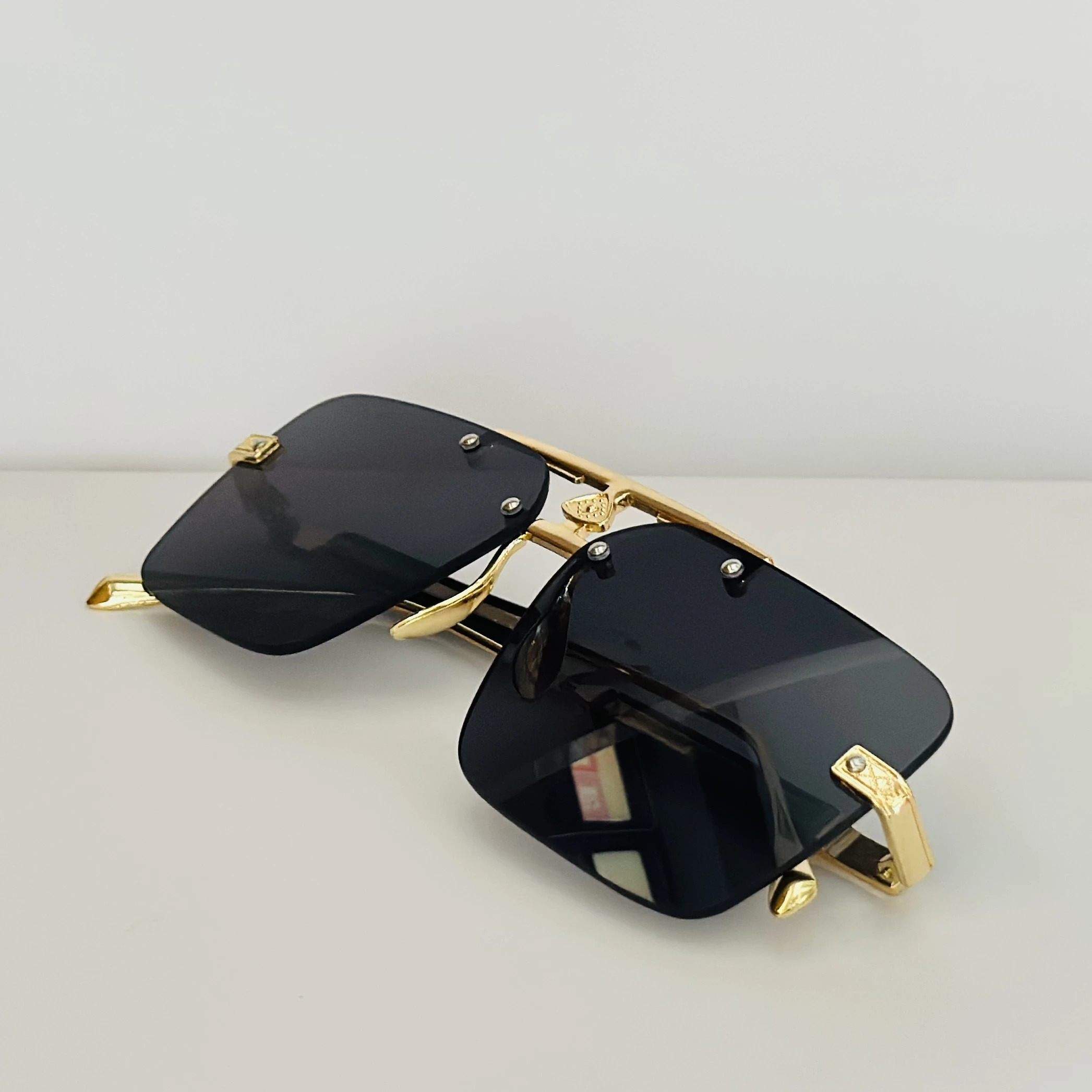 Maybach square gold-framed sunglasses with black lenses.