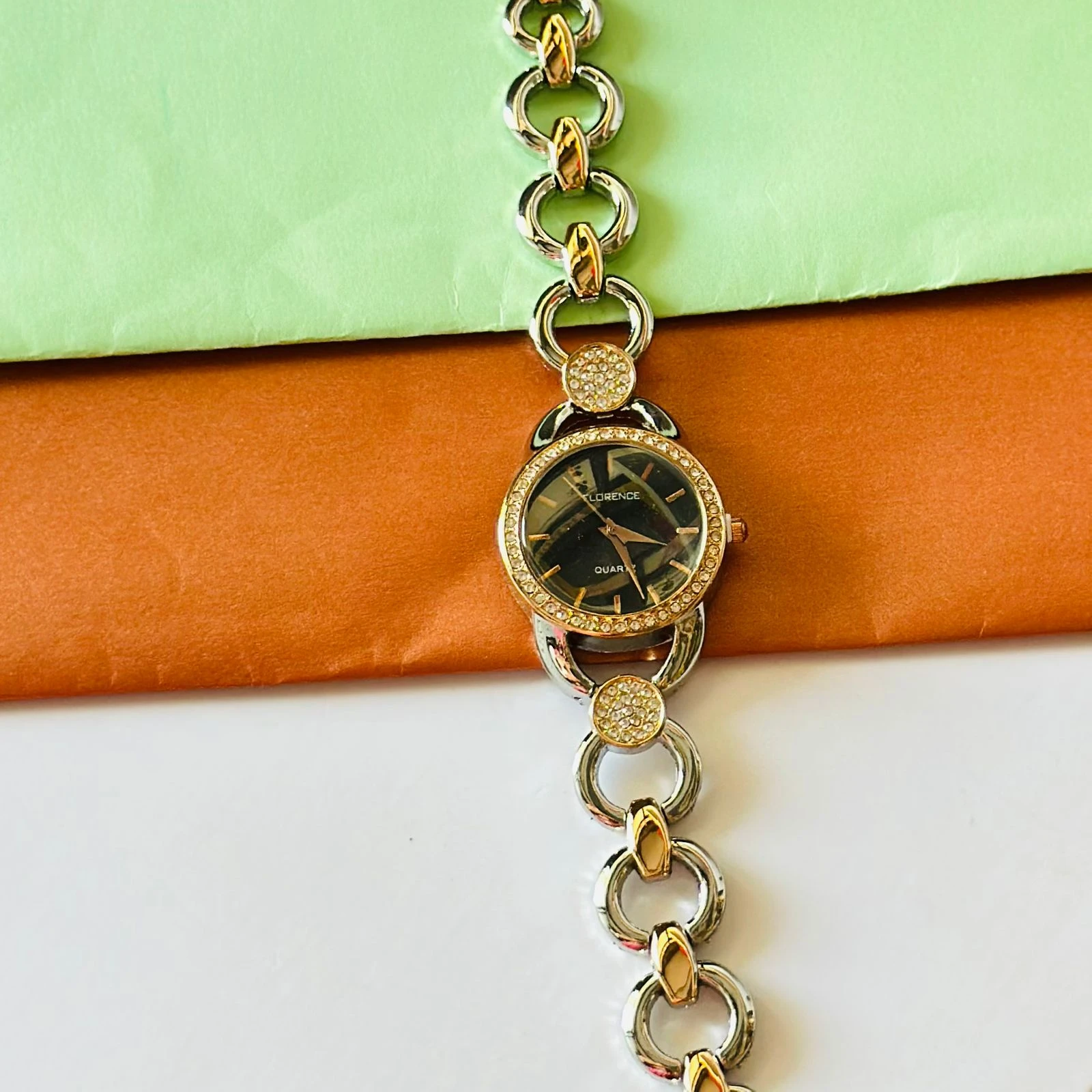 Class Analog Diamond Studded Floral Designer Bracelet Watch in white and golden color.