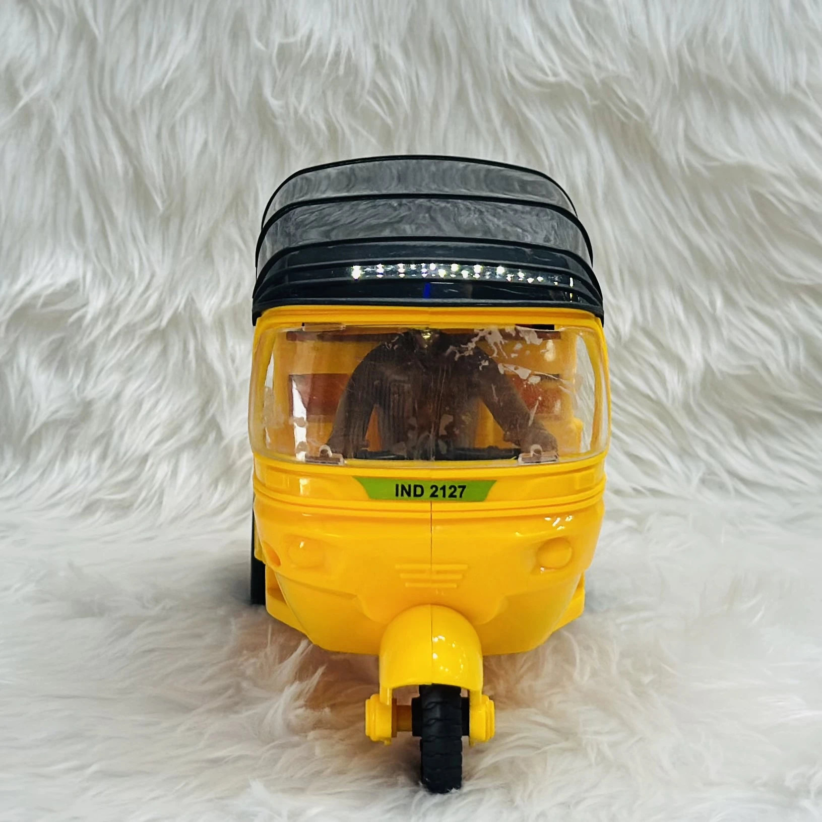 Yellow plastic toy auto rickshaw.