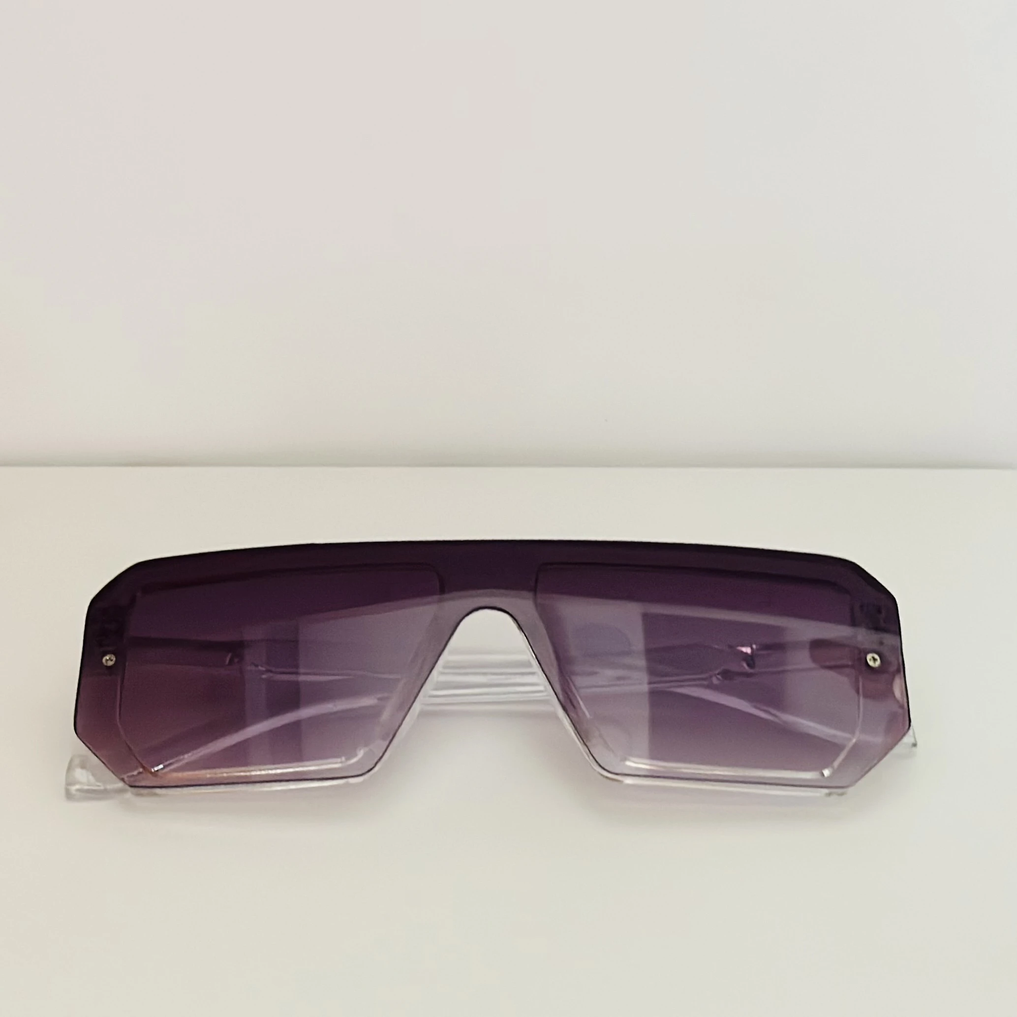 Oversized shield sunglasses with a rimless, flat-top design and purple gradient lenses.