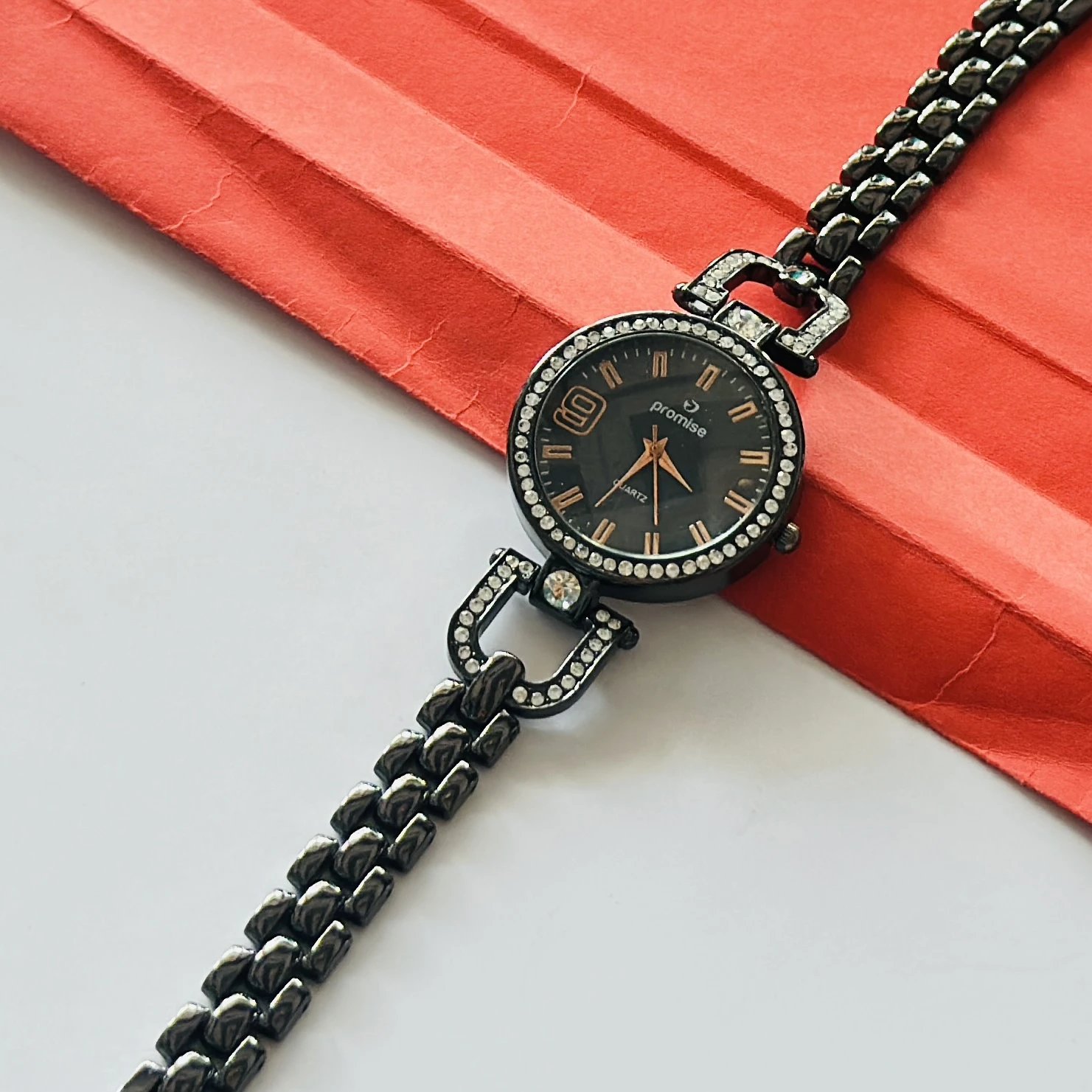 women's bracelet watch featuring a black dial and a diamond-studded bezel.