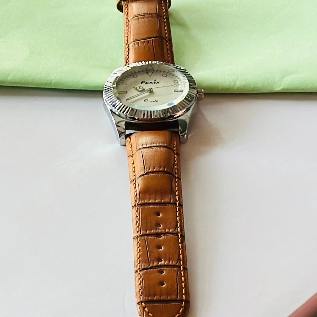 Round analog watch with a brown leather strap