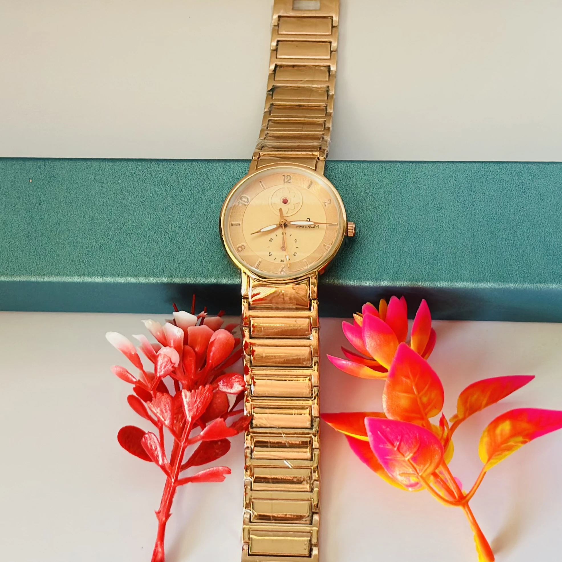 Gold -tone women's analog watch with a metal link bracelet.