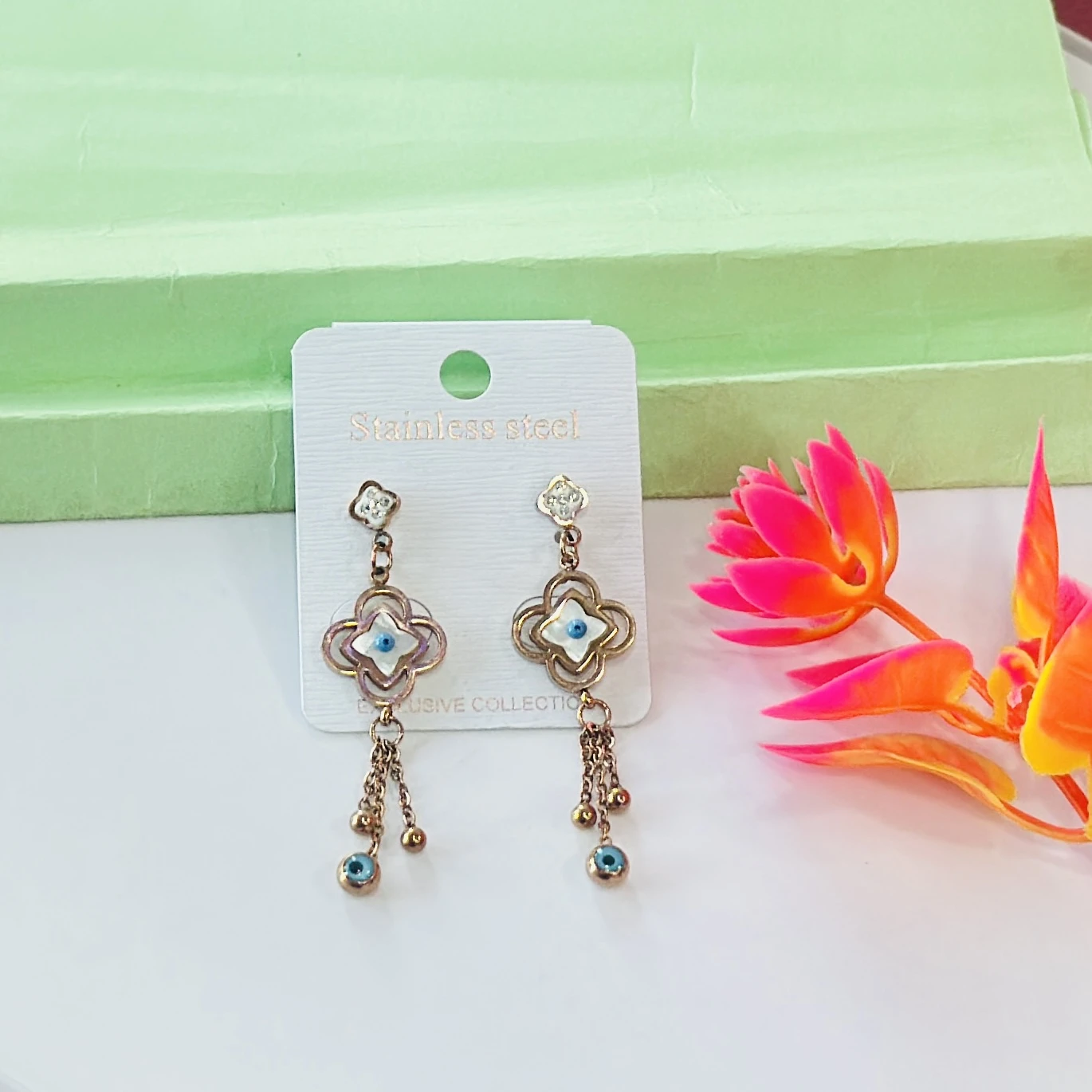 Rose gold-toned, stainless steel flower and evil eye drop earrings.