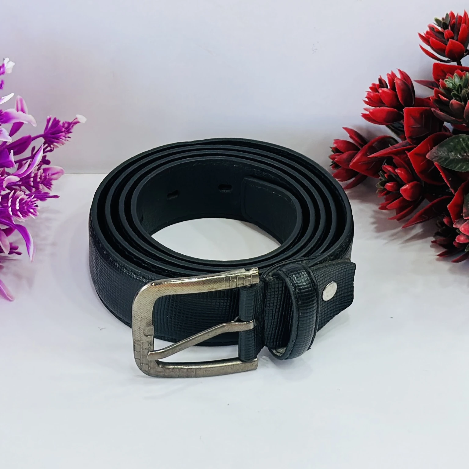 Black leather belt with a metal buckle.