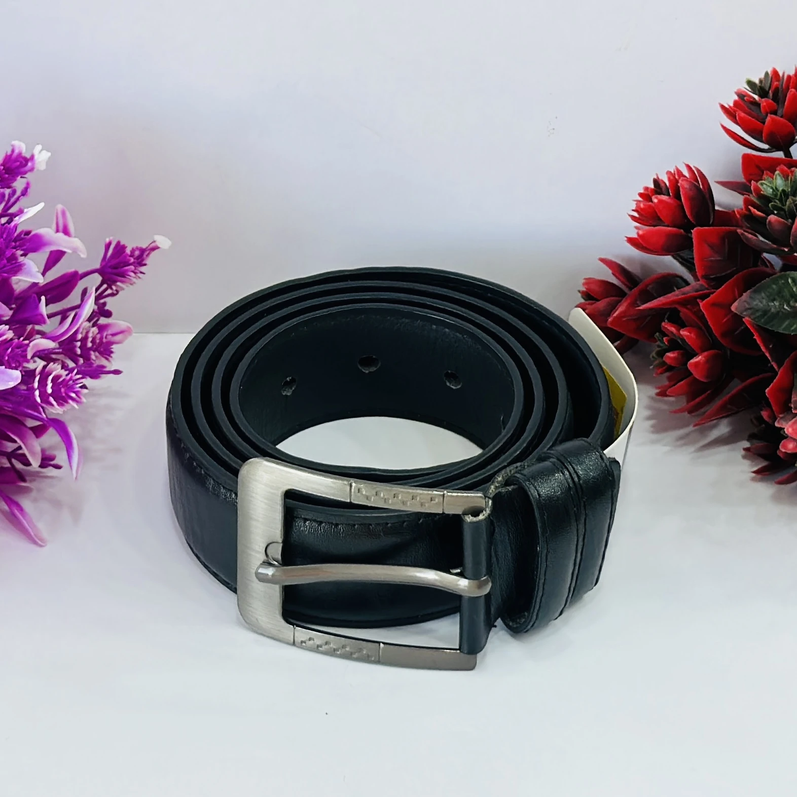 Men’s black leather belt with a metal buckle.