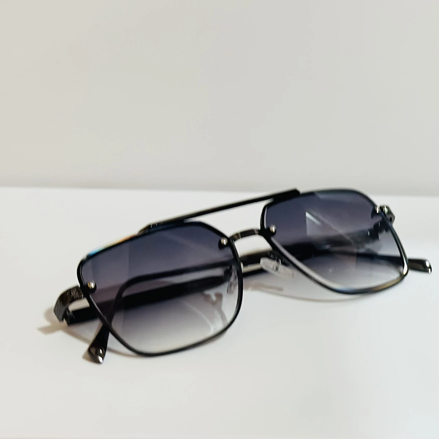 pair of black and grey gradient square sunglasses with a metal frame.