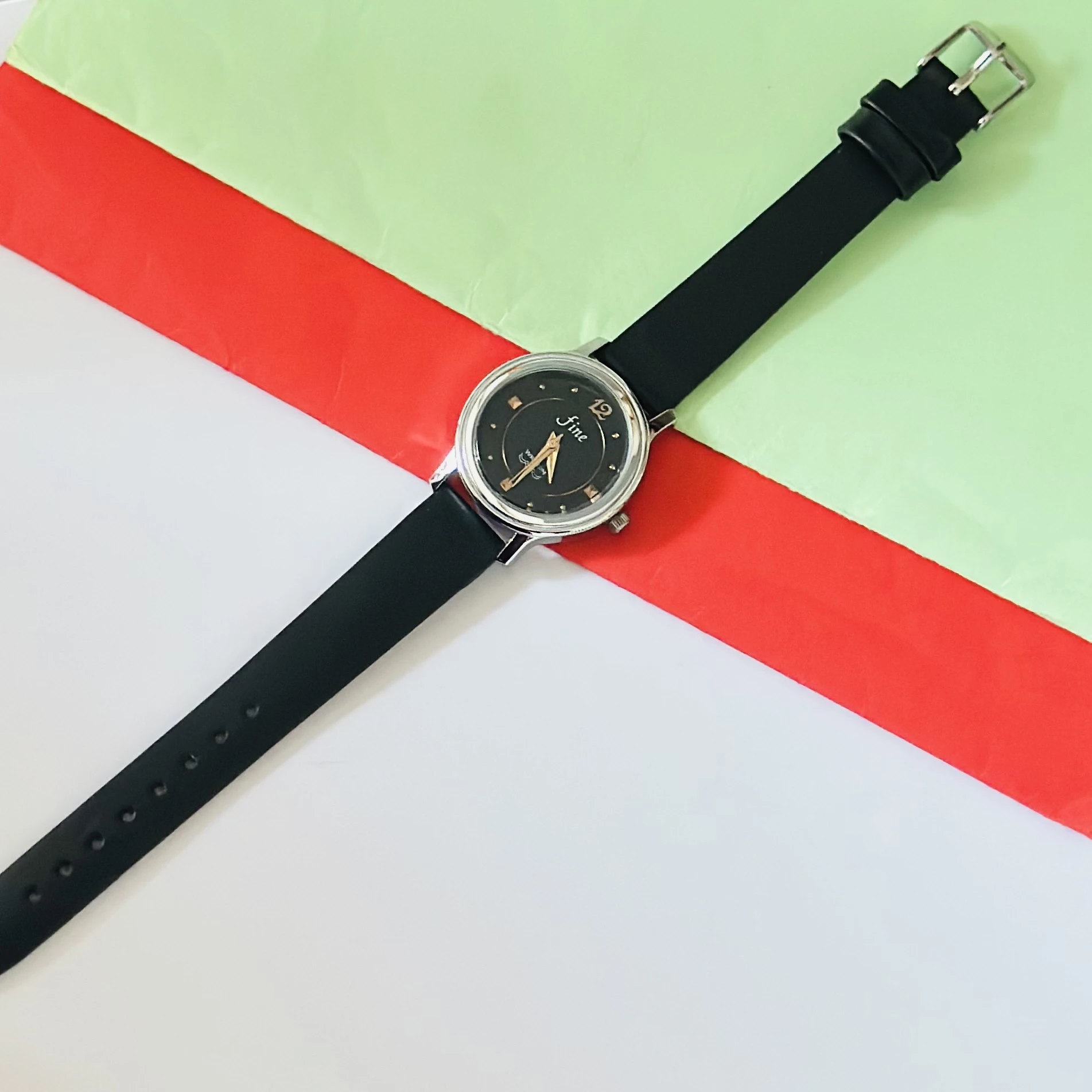 Black analog watch with a black strap.
