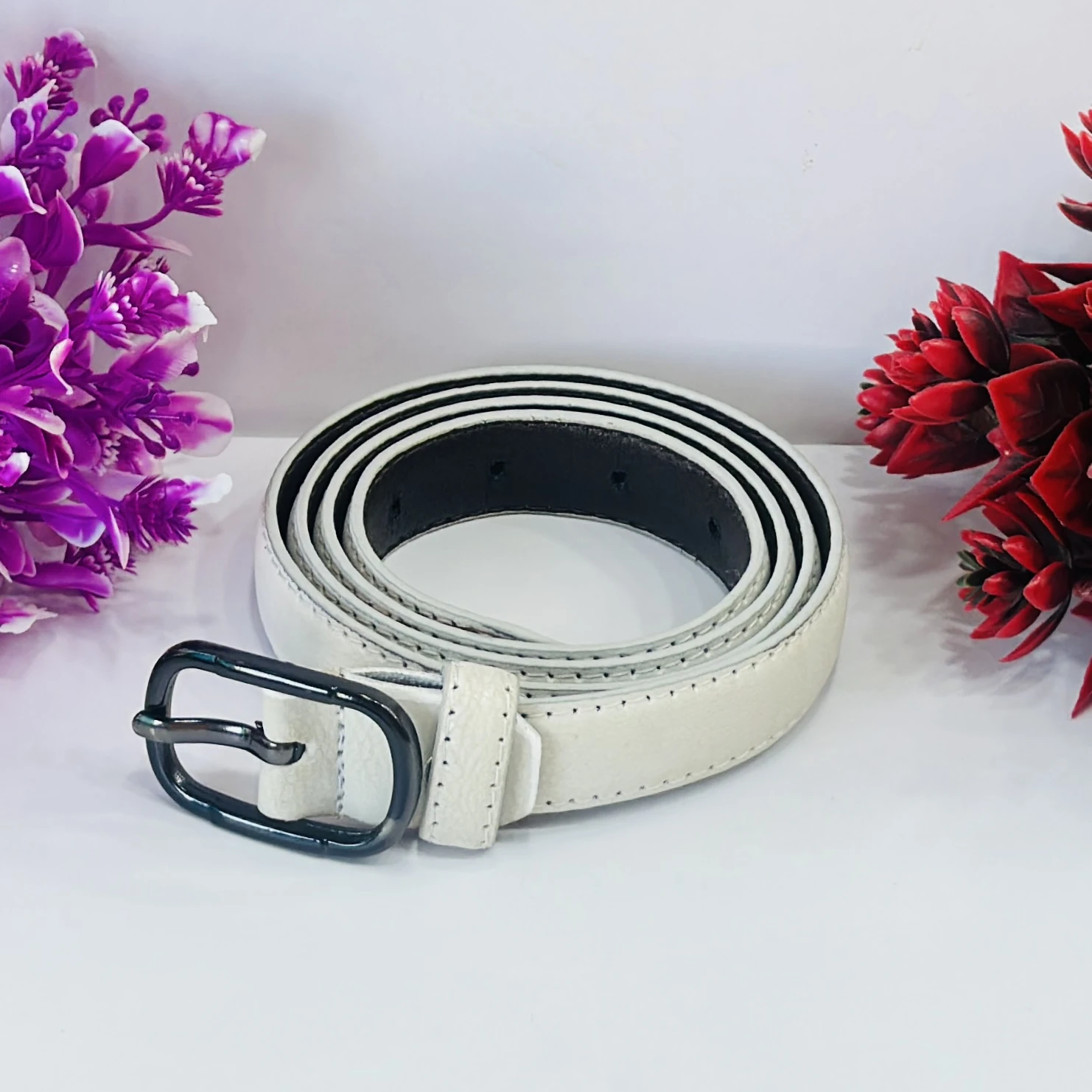 white leather women's belt with a black buckle.