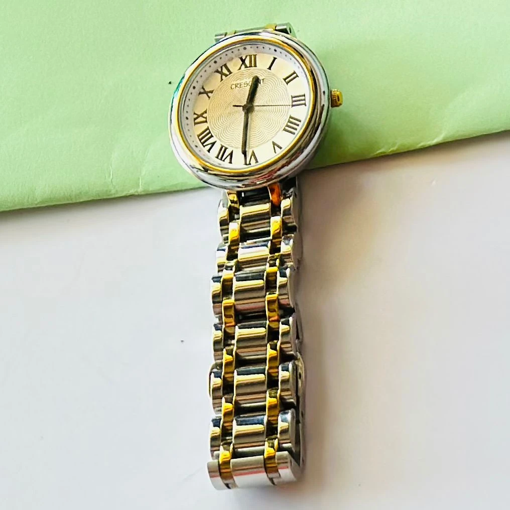 Crescent analog watch with a rectangular case and a two-tone (silver and gold) metal bracelet.
