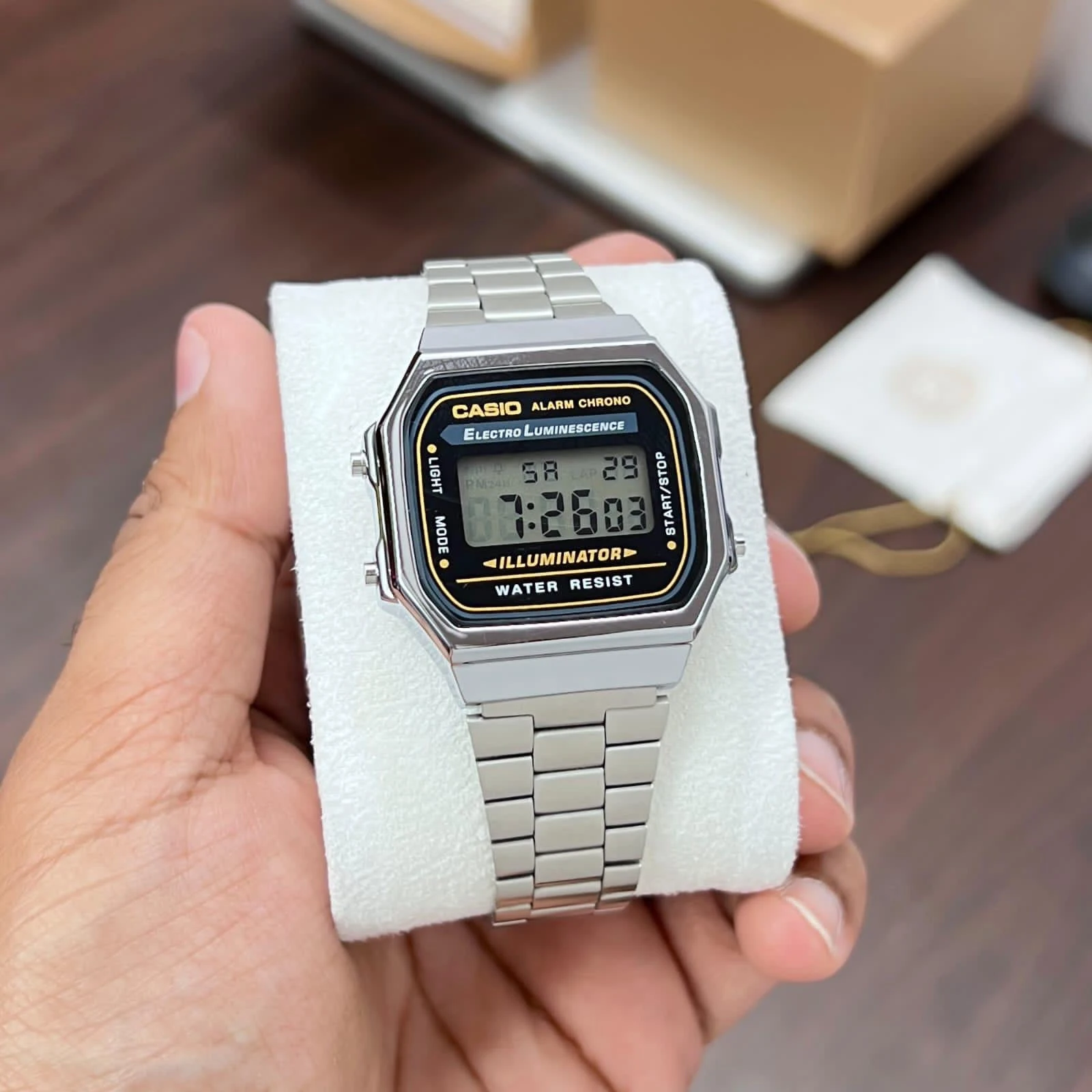 Digital watch with a gold-tone case and stainless steel band.