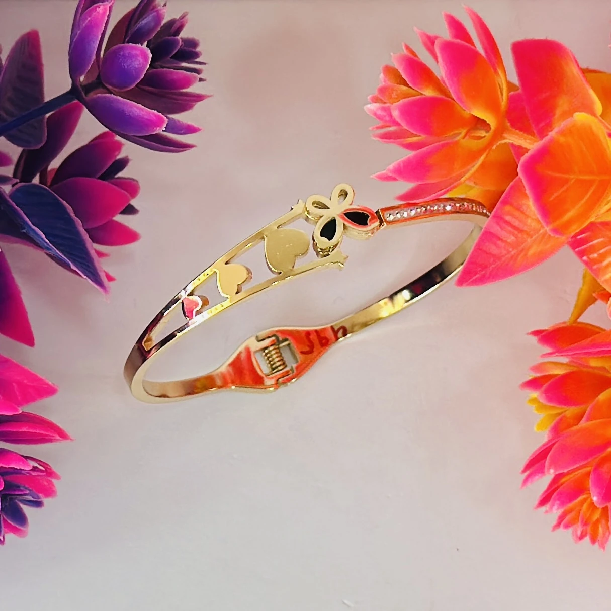 Gold plated bangle bracelet with a butterfly and heart design