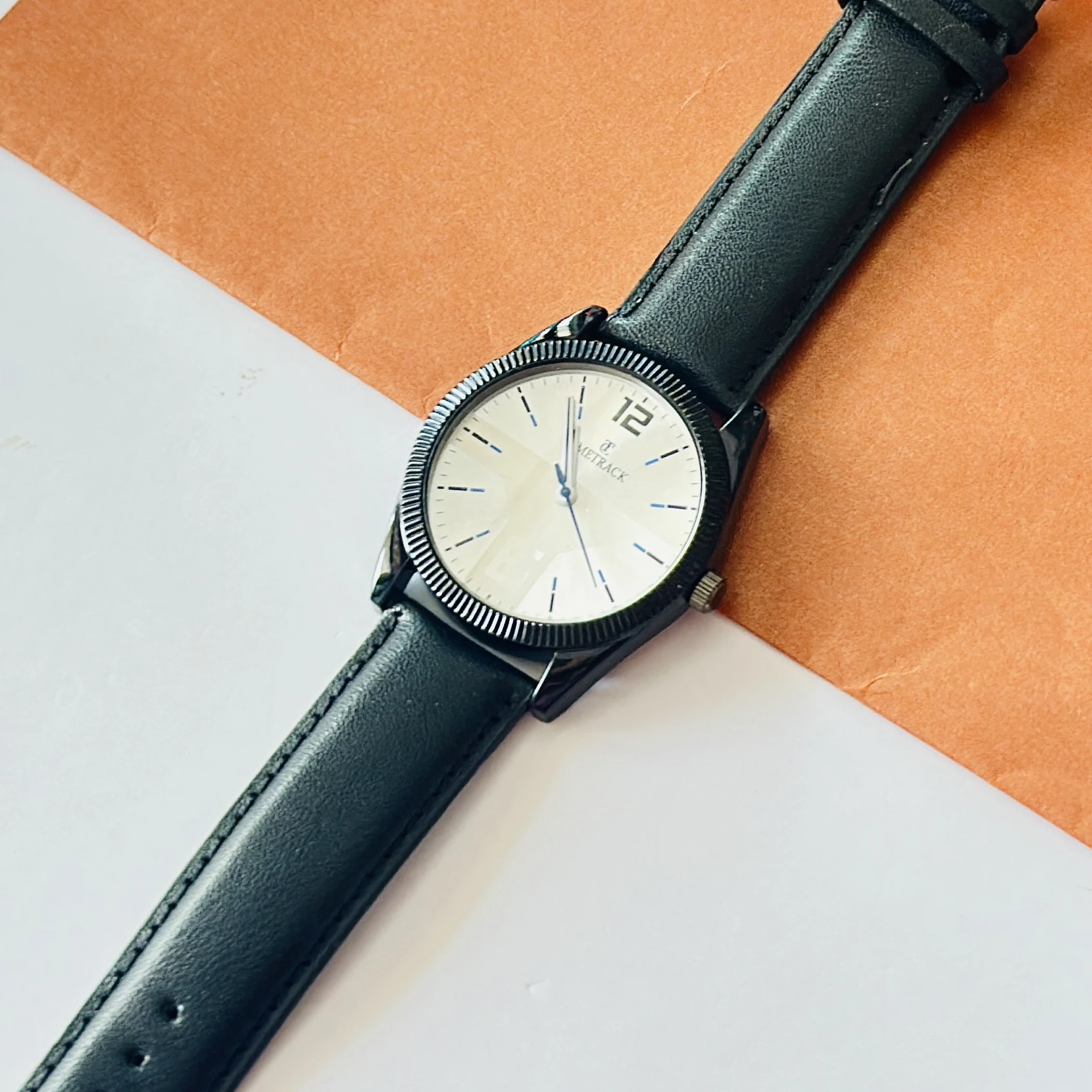 Timrack analog wristwatch featuring a silver-toned bezel, a black dial