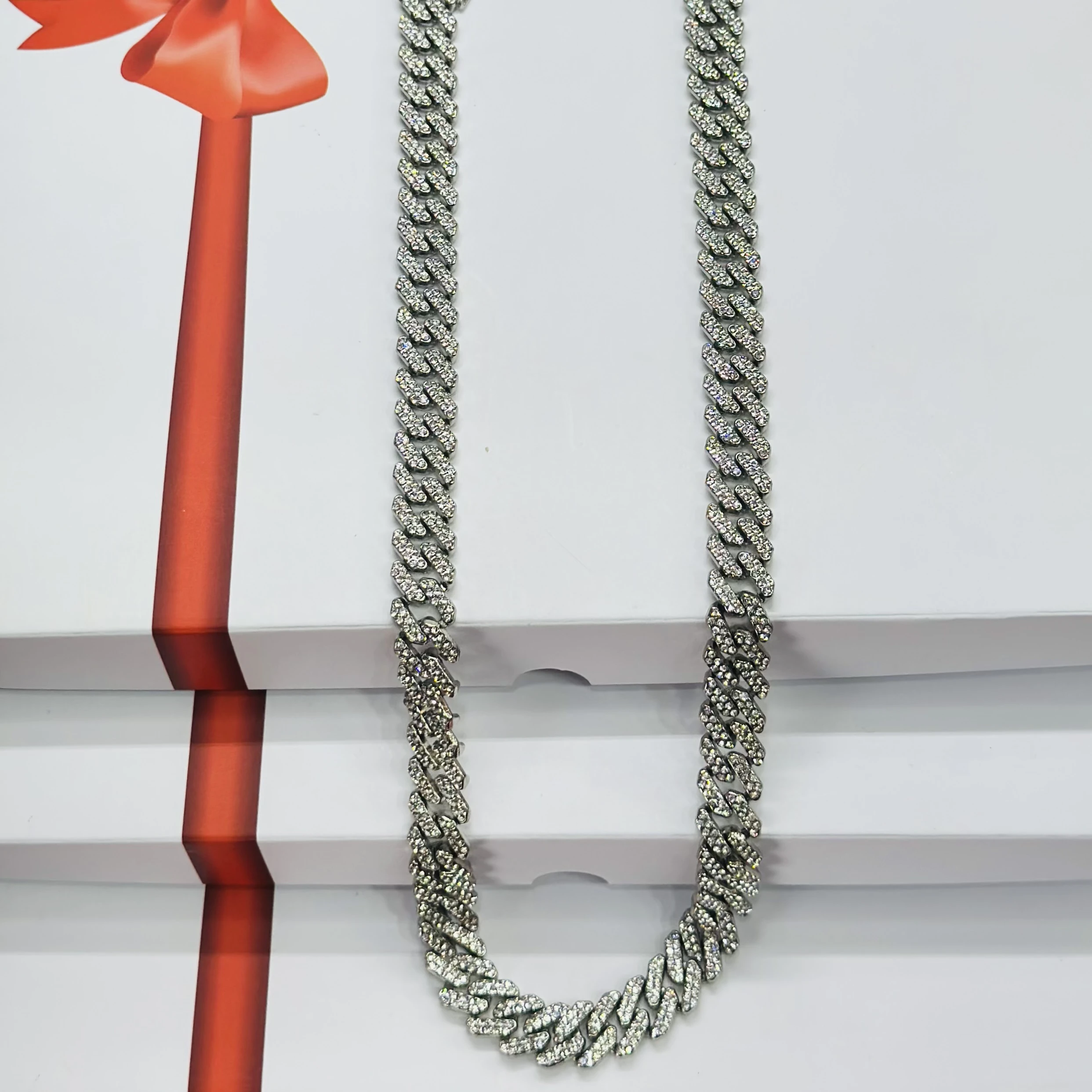 An iced-out silver-plated Cuban link chain necklace with cubic zirconia stones.