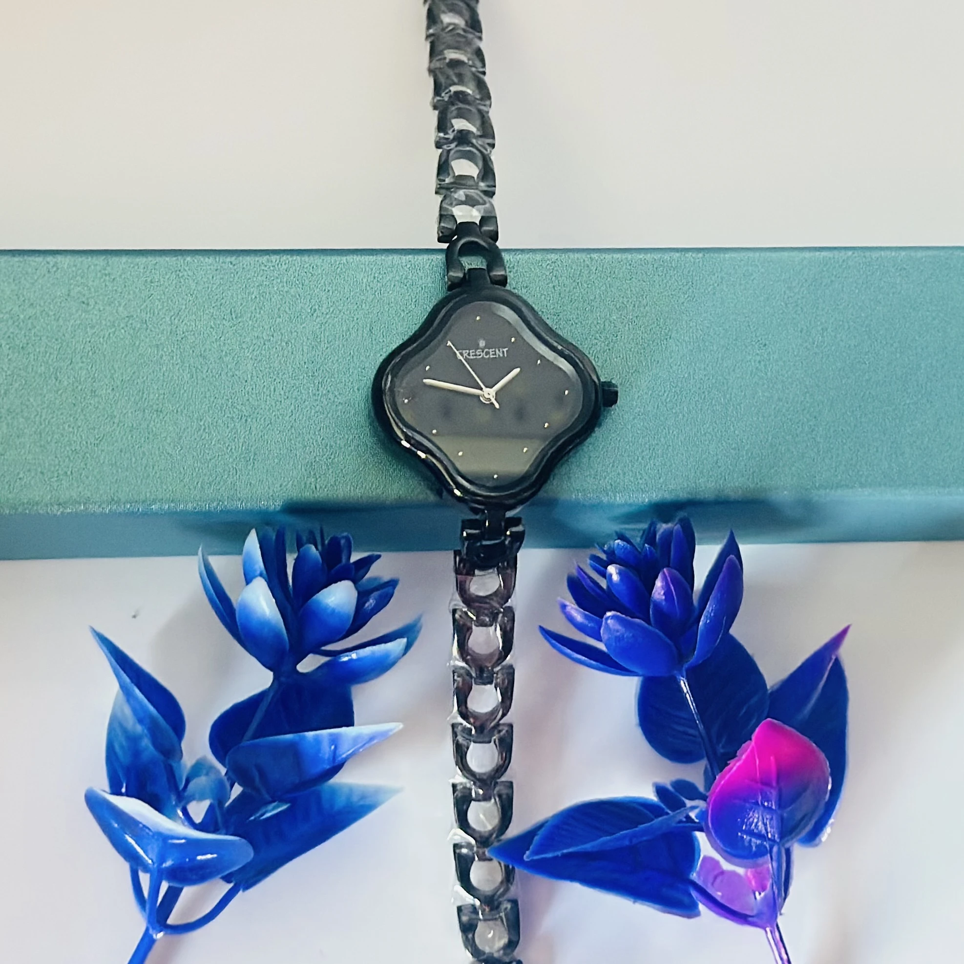 Black dial analog watch for women with a black bi-metal strap.