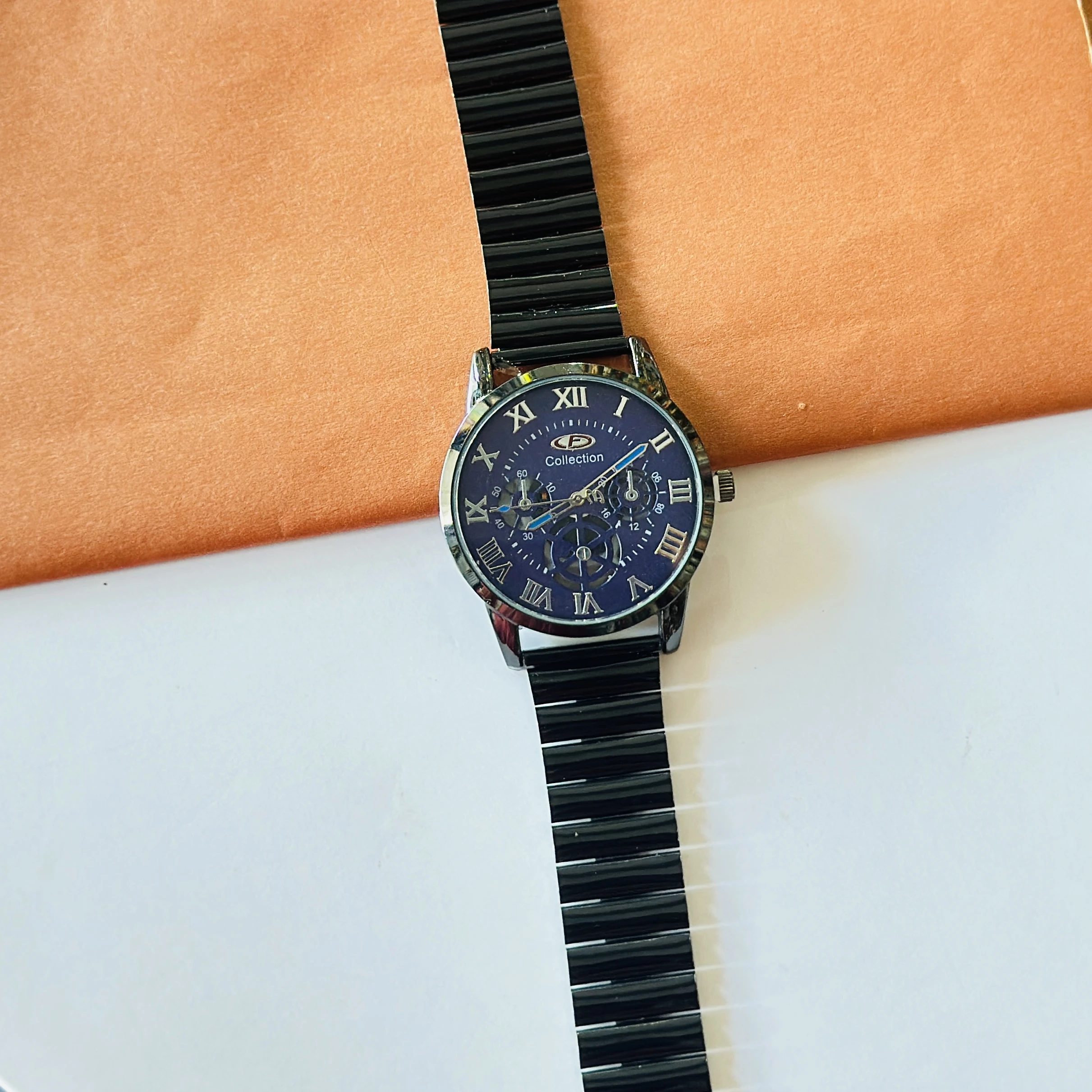 Black stainless steel OLEVS analog watch for men with a blue roman numeral dial.
