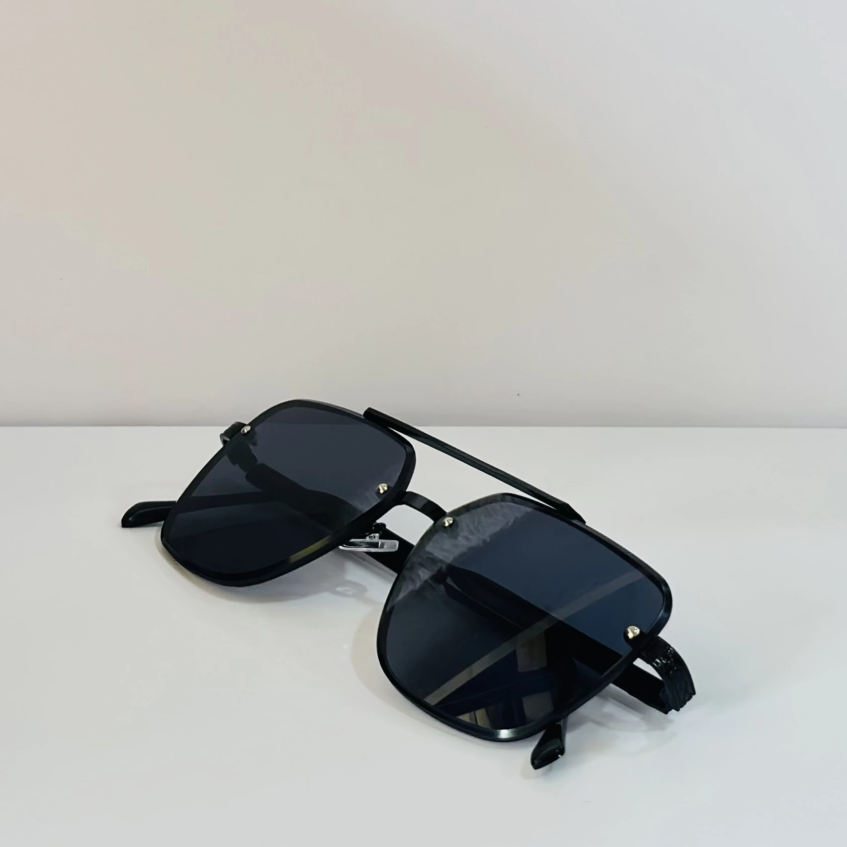 pair of MOONX Celebrity black UV protected sunglasses with a black frame.