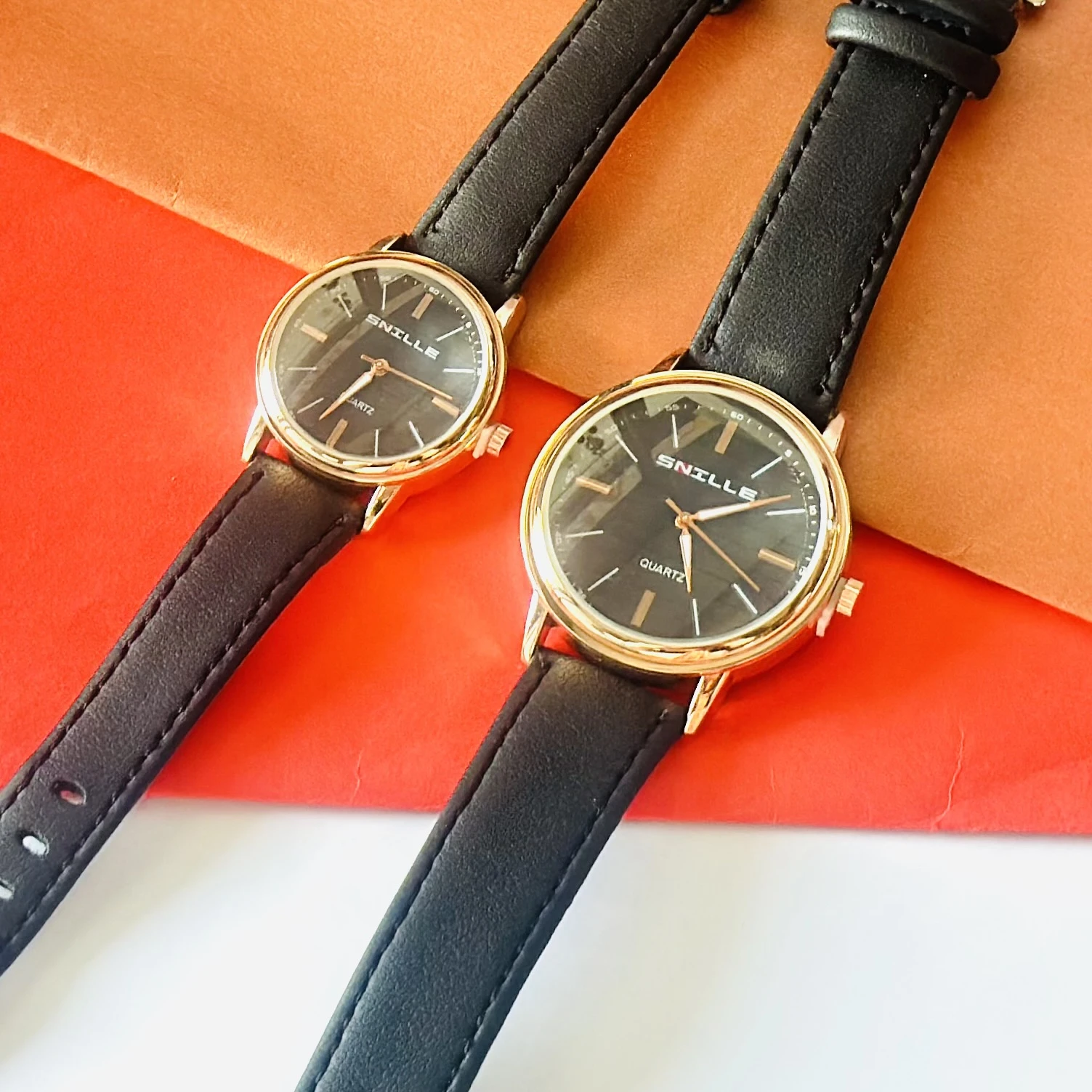 black "Snille" quartz watches with gold-tone cases and black faux leather straps