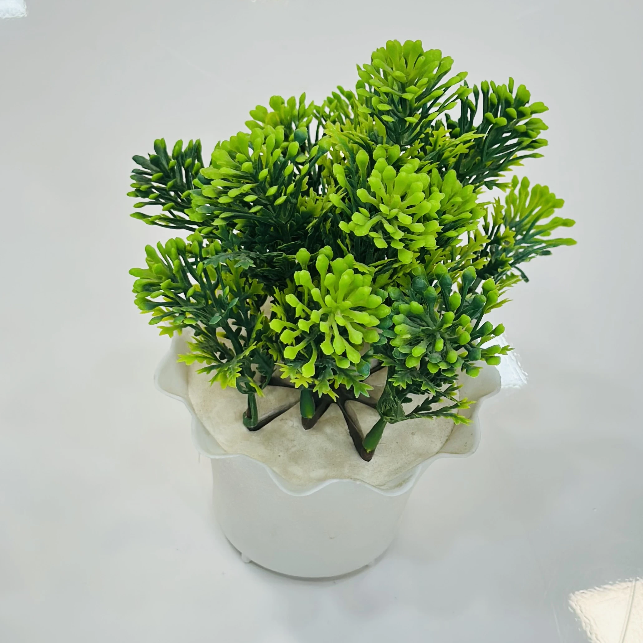 small, artificial potted plant, likely made from plastic materials.