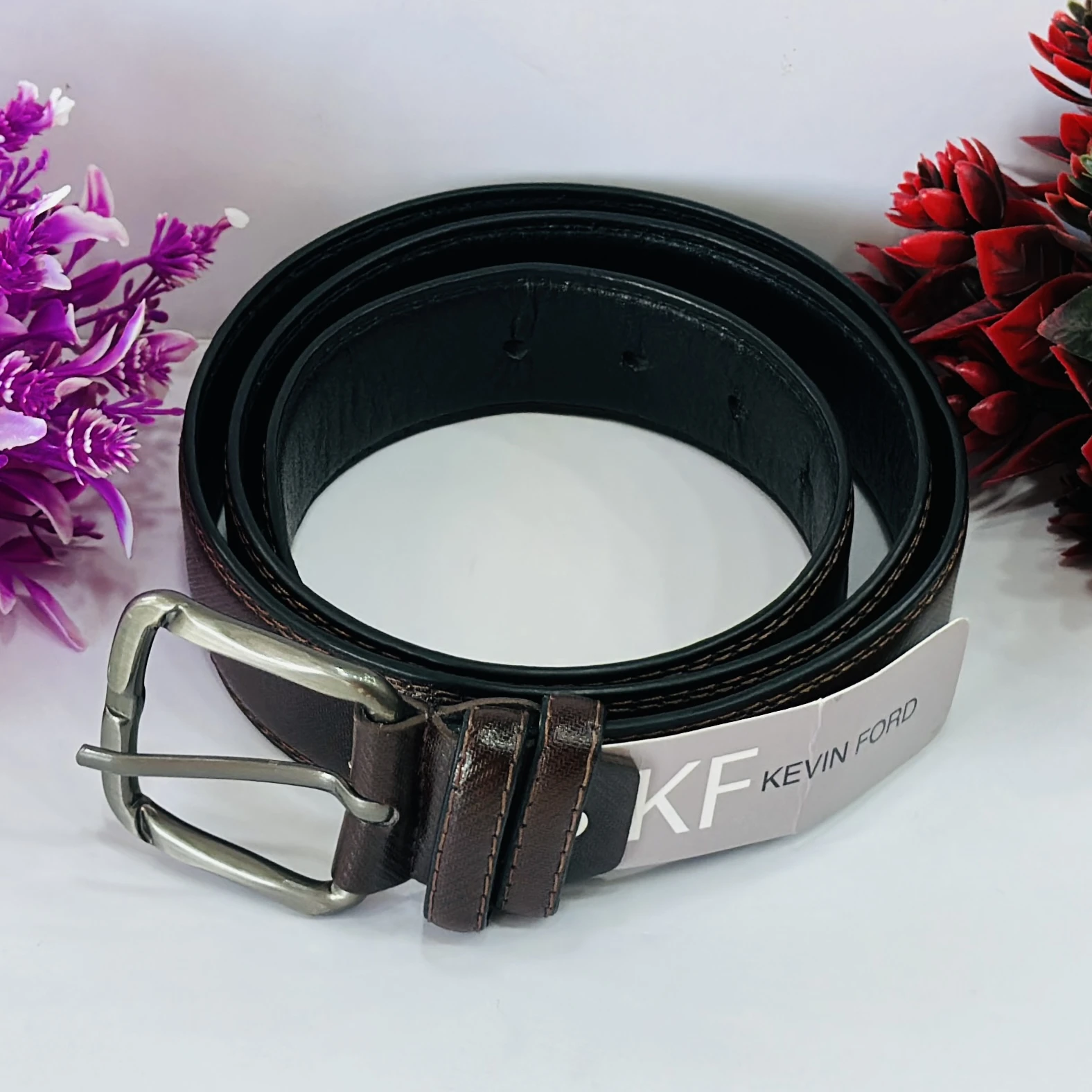 Brown leather belt with a pin buckle.