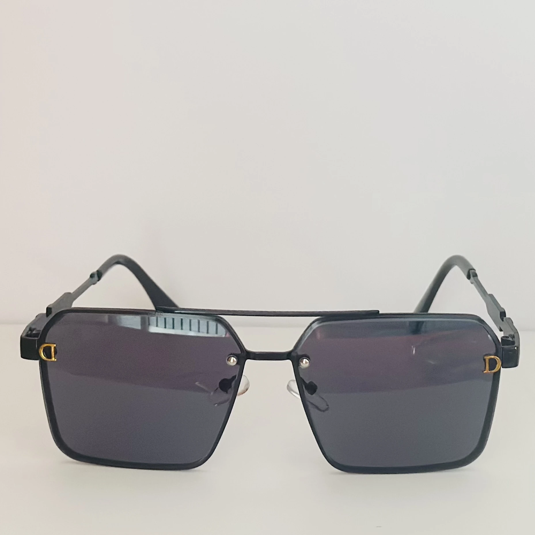 black pilot-style sunglasses with grey polycarbonate lenses.