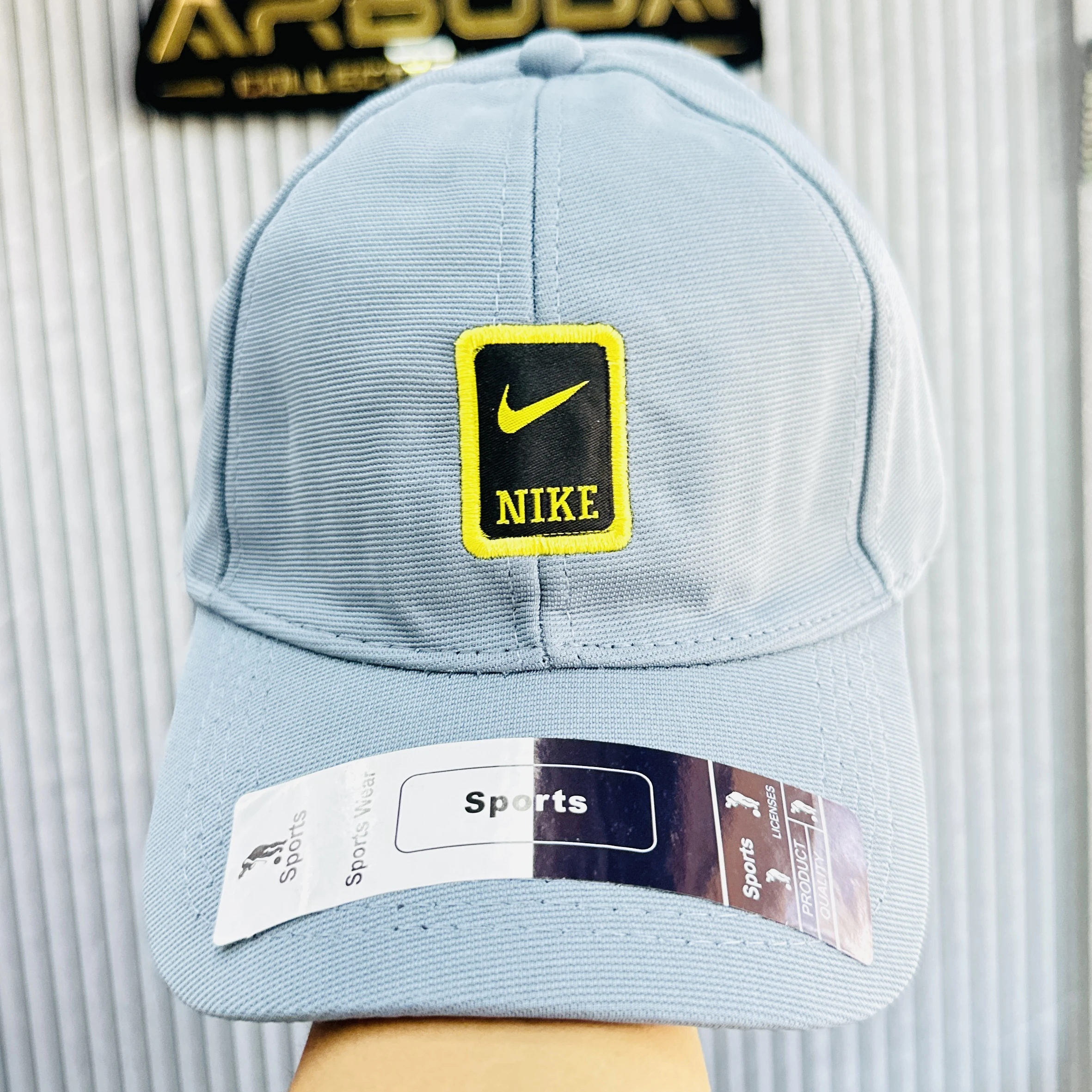 Blue Nike baseball cap featuring a yellow and black logo patch on the front.