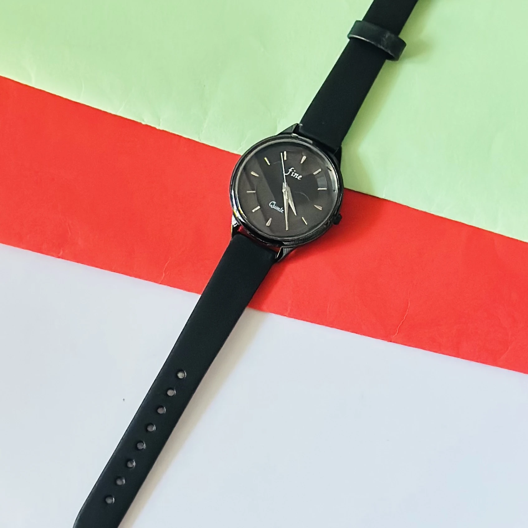 Black analog quartz wrist watch with a black strap.