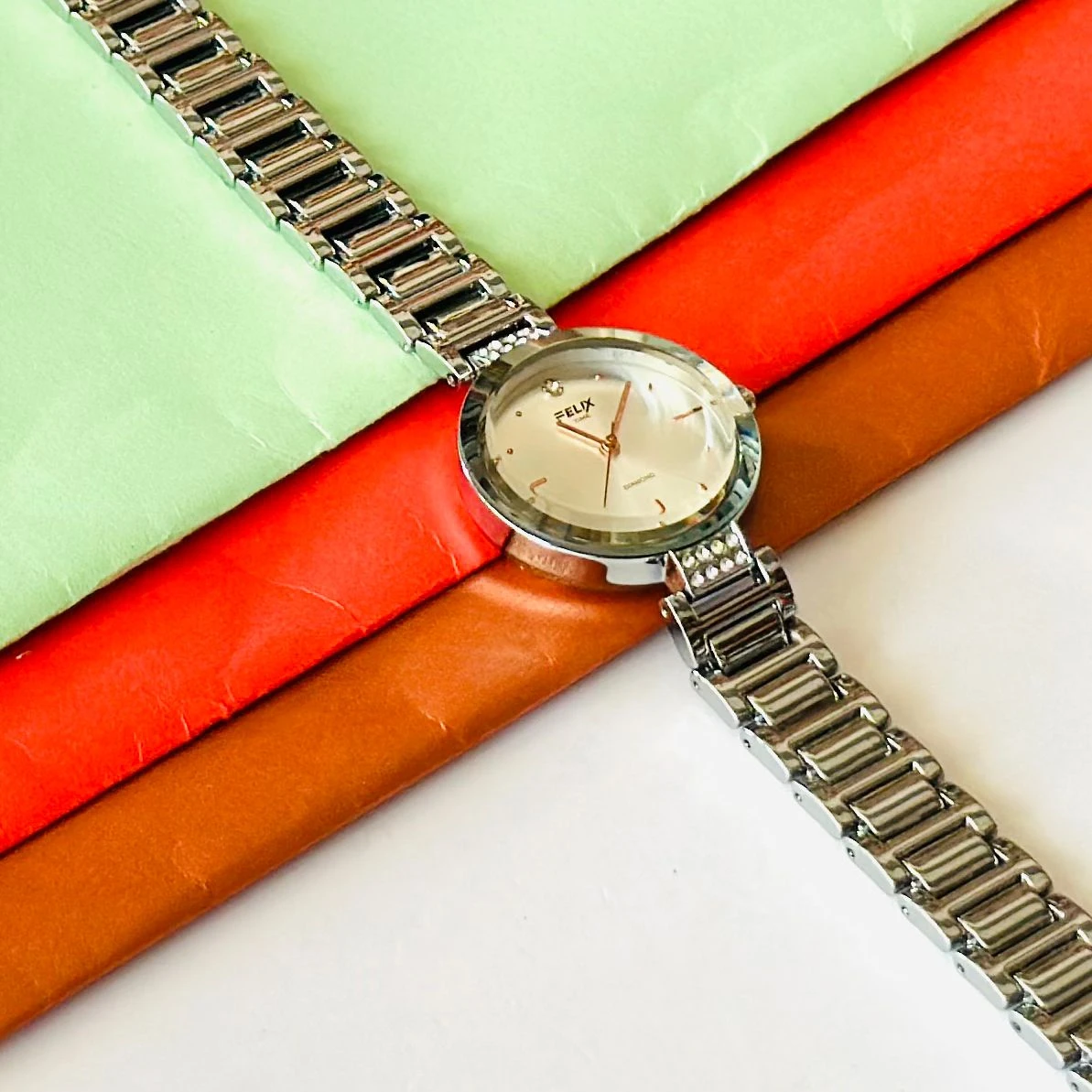 analog watch with a white dial and a rose gold metal strap