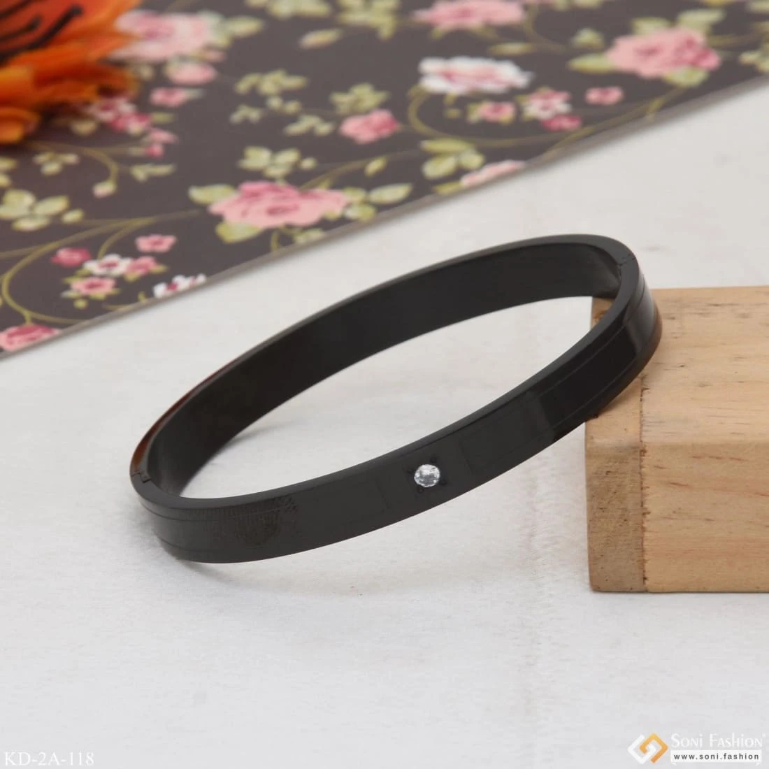 Black stainless steel kada bracelet with a single crystal accent.