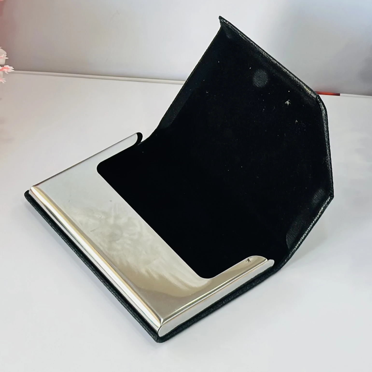 Black faux leather and metal business card holder.