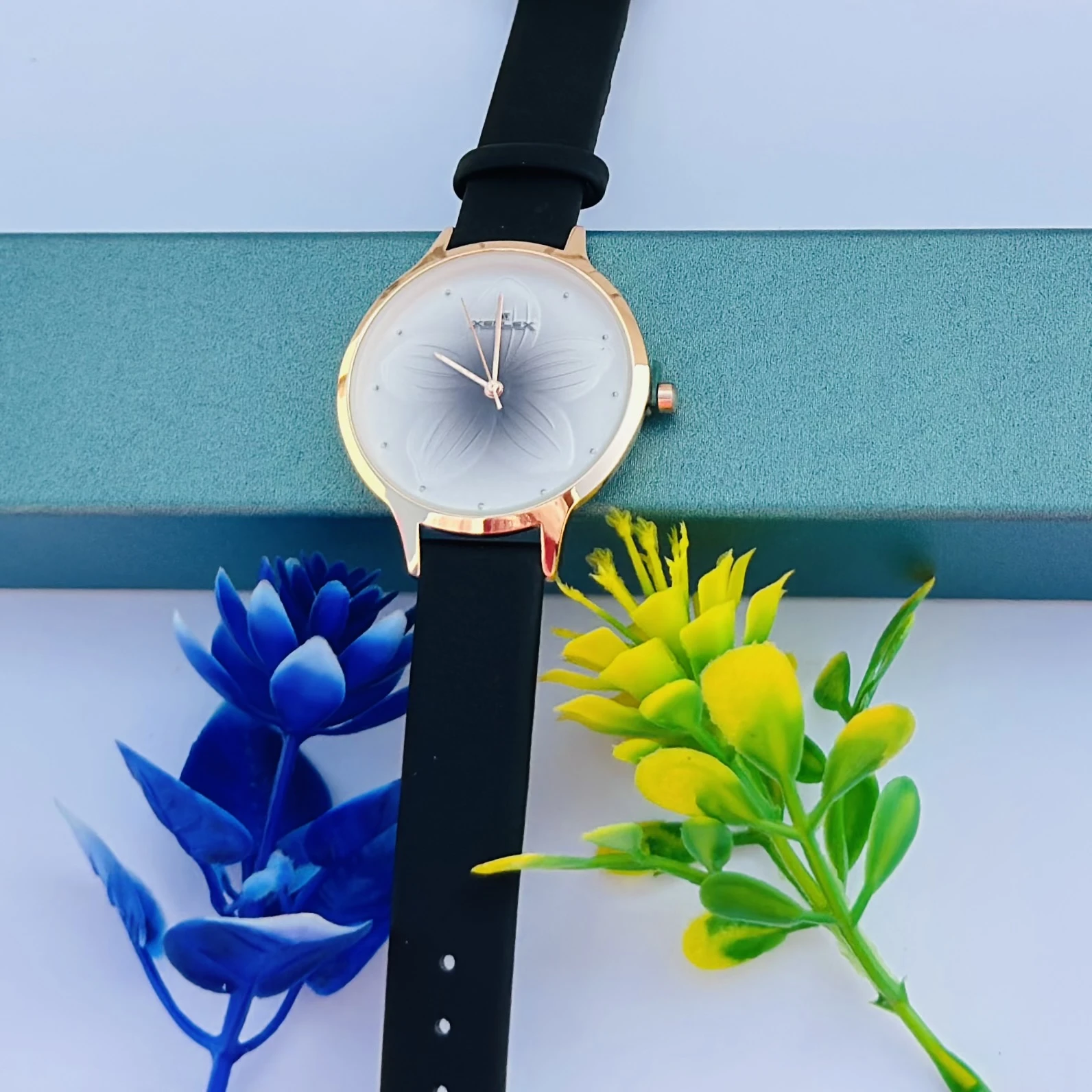 Analog with Pink Dial watch for women with a black plastic strap.